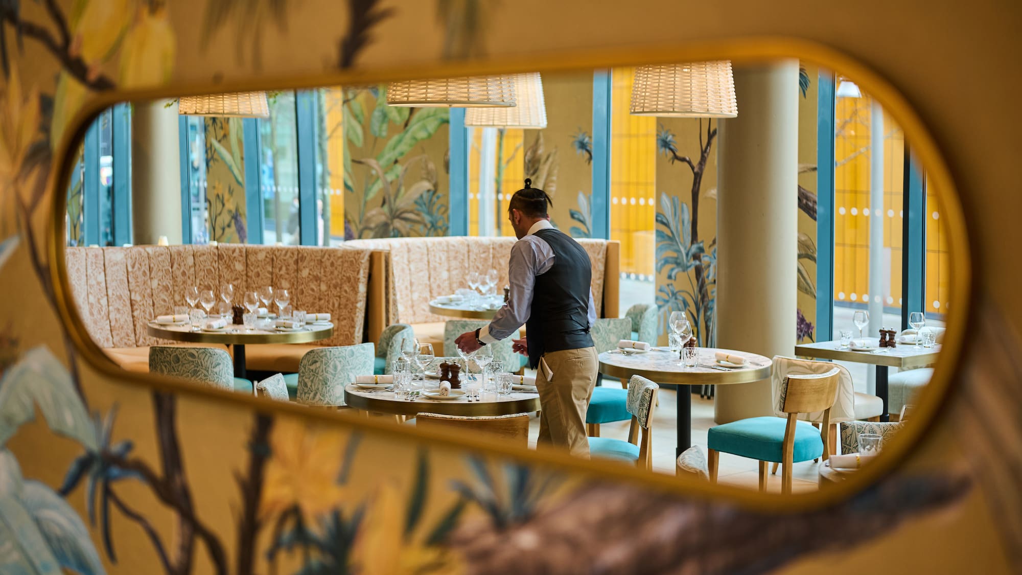 a man standing at tables in a restaurant