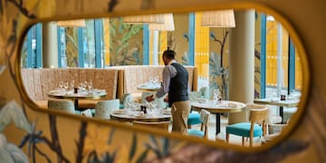 a man standing at tables in a restaurant