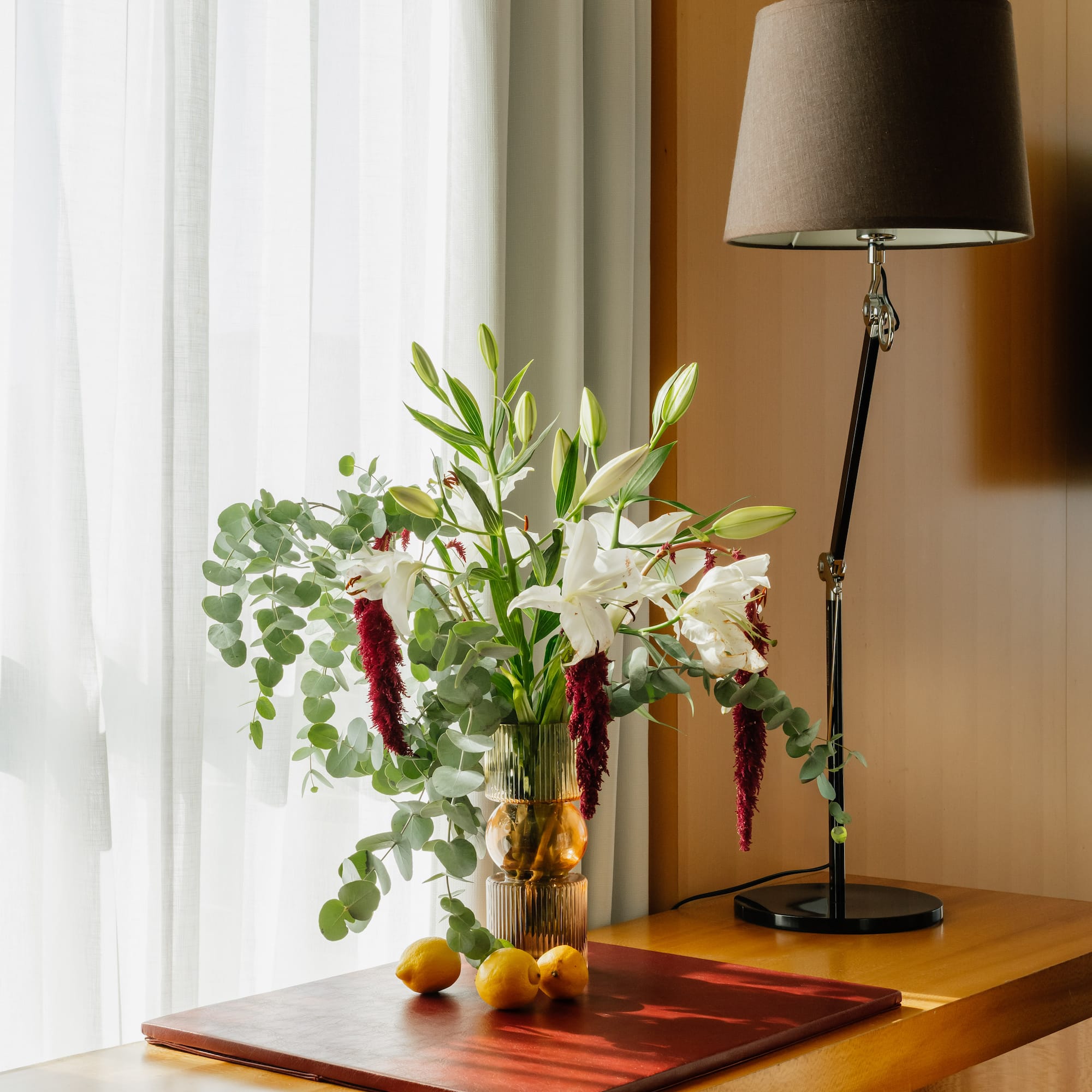a vase of flowers and a lamp on a table