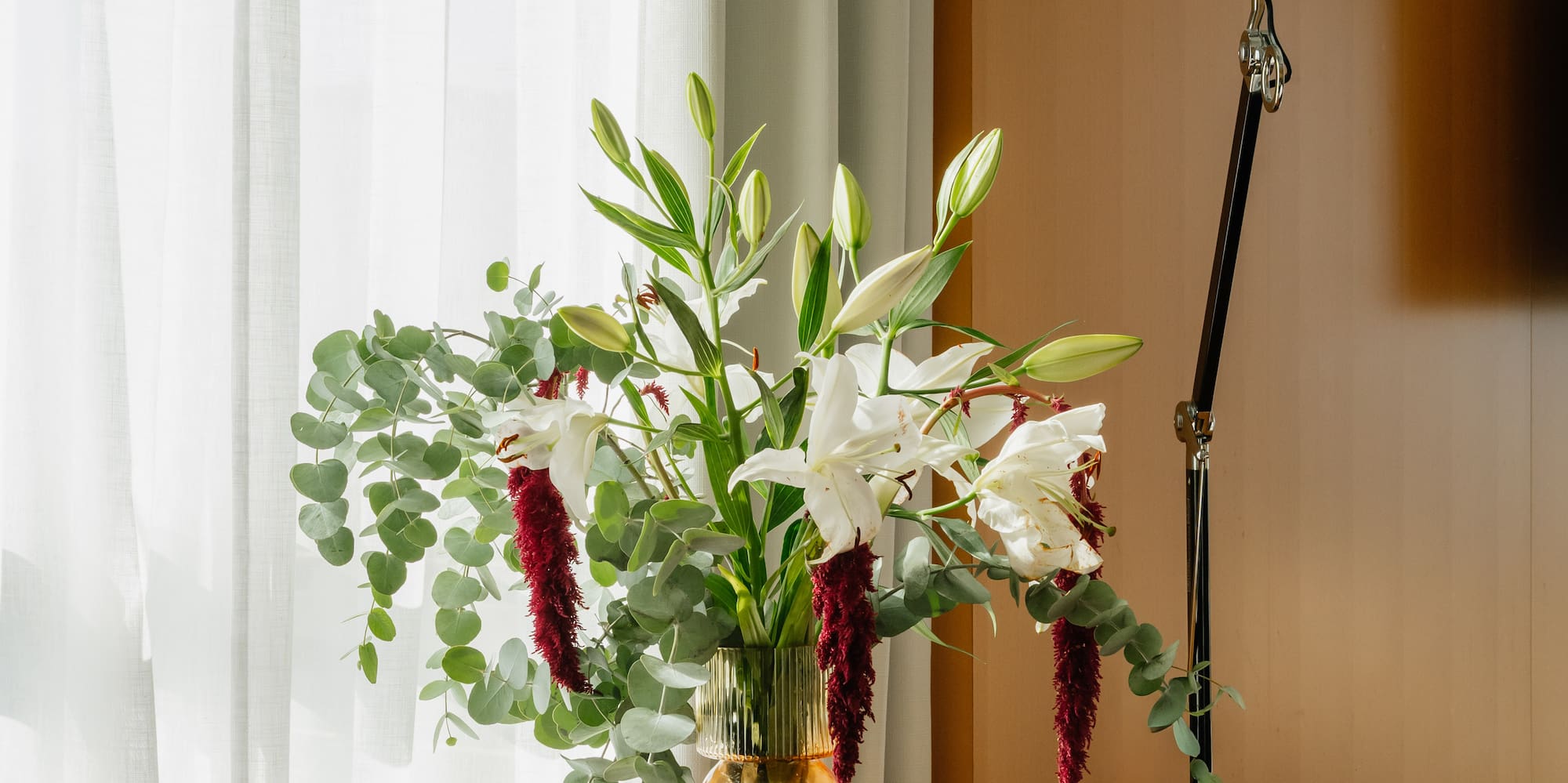 a vase of flowers and a lamp on a table