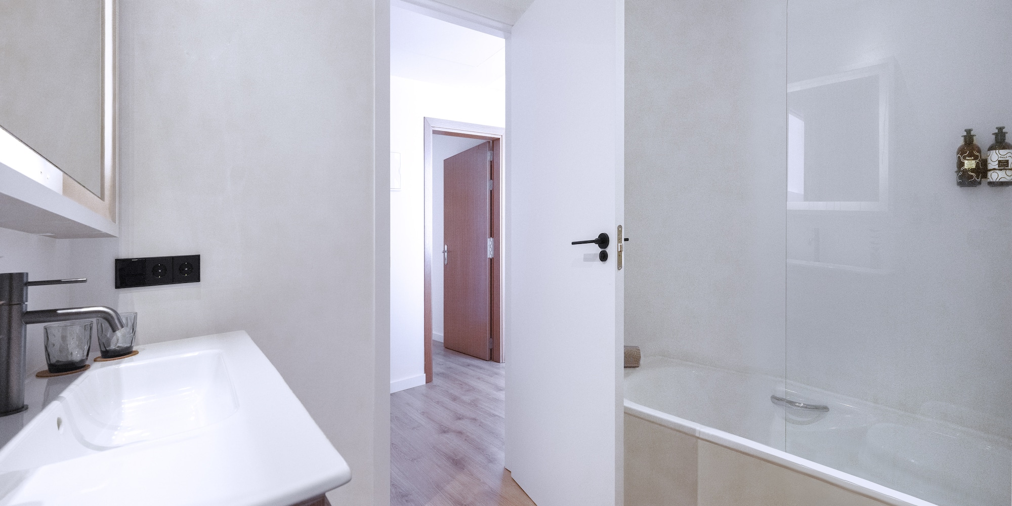 a bathroom with a white door and a bathtub