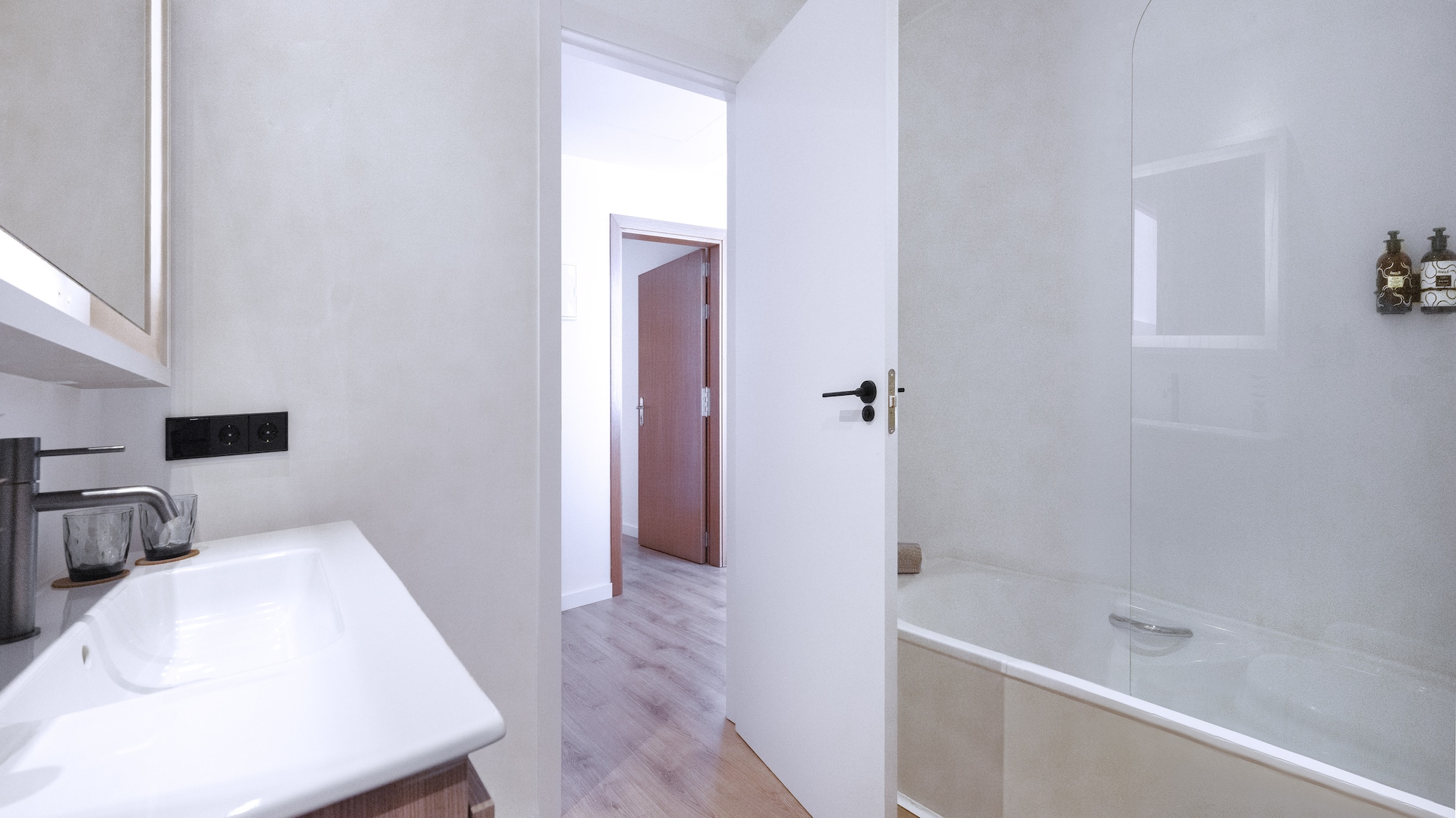 a bathroom with a white door and a bathtub