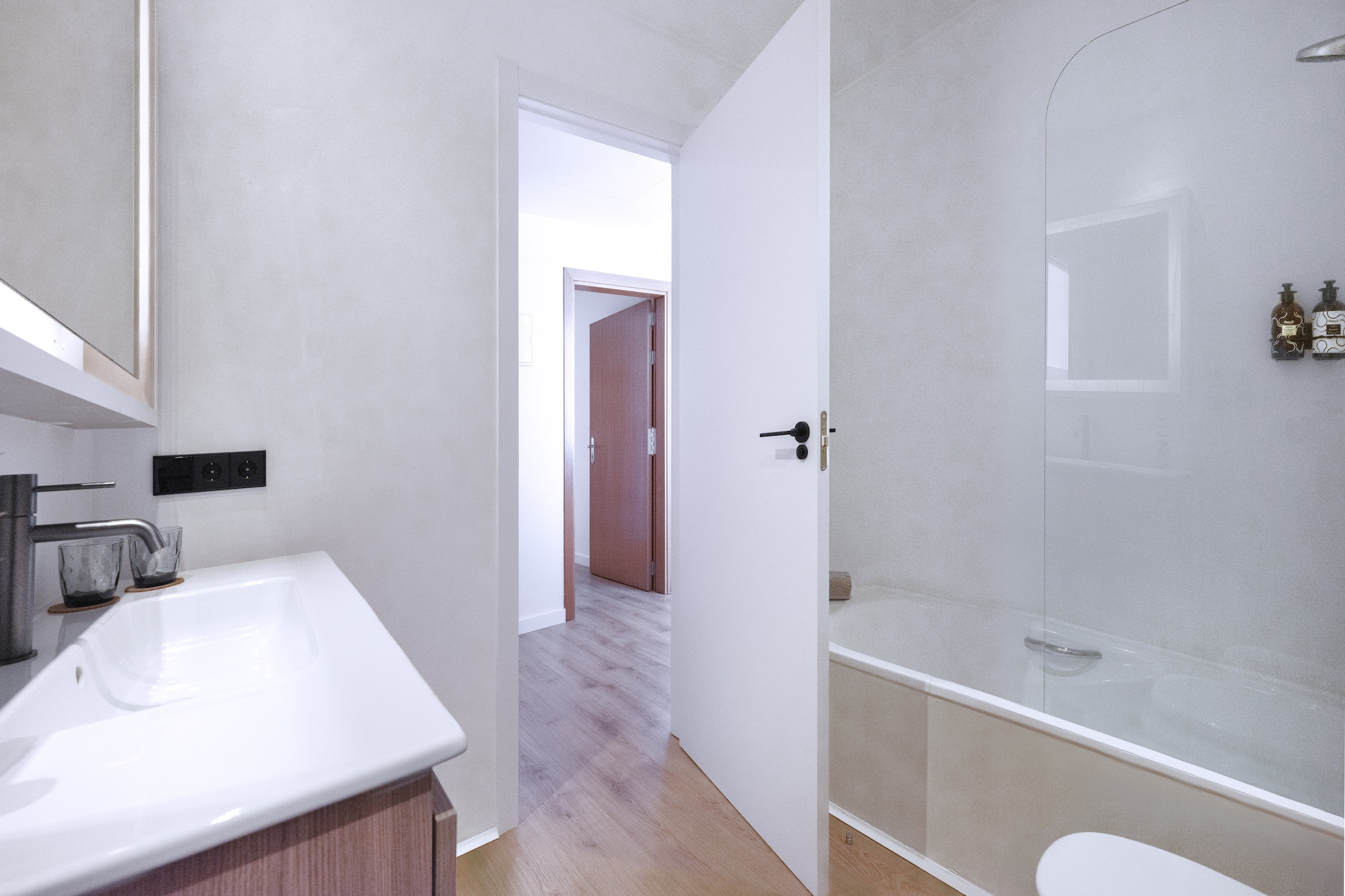 a bathroom with a white door and a bathtub