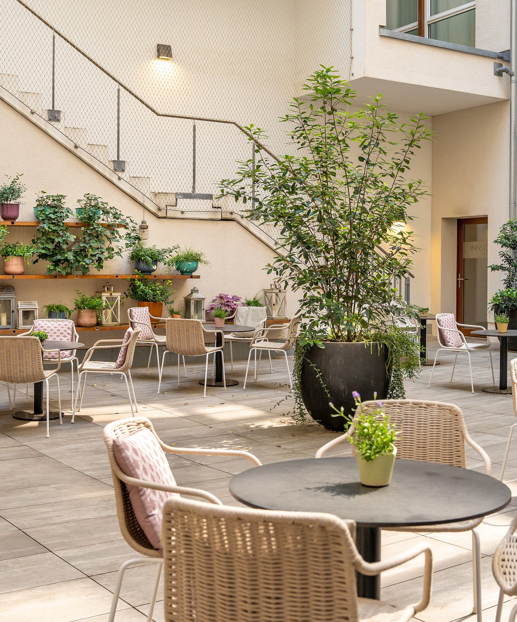 a patio with chairs and tables and plants