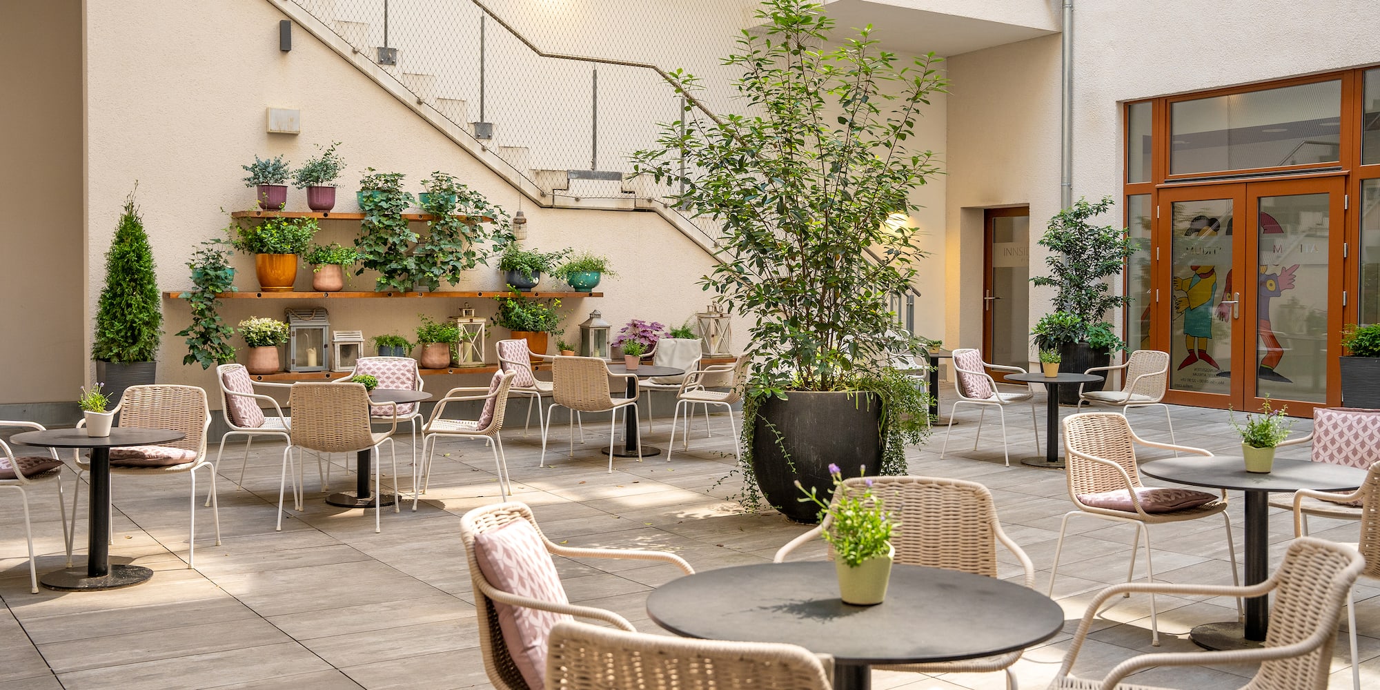 a patio with chairs and tables and plants