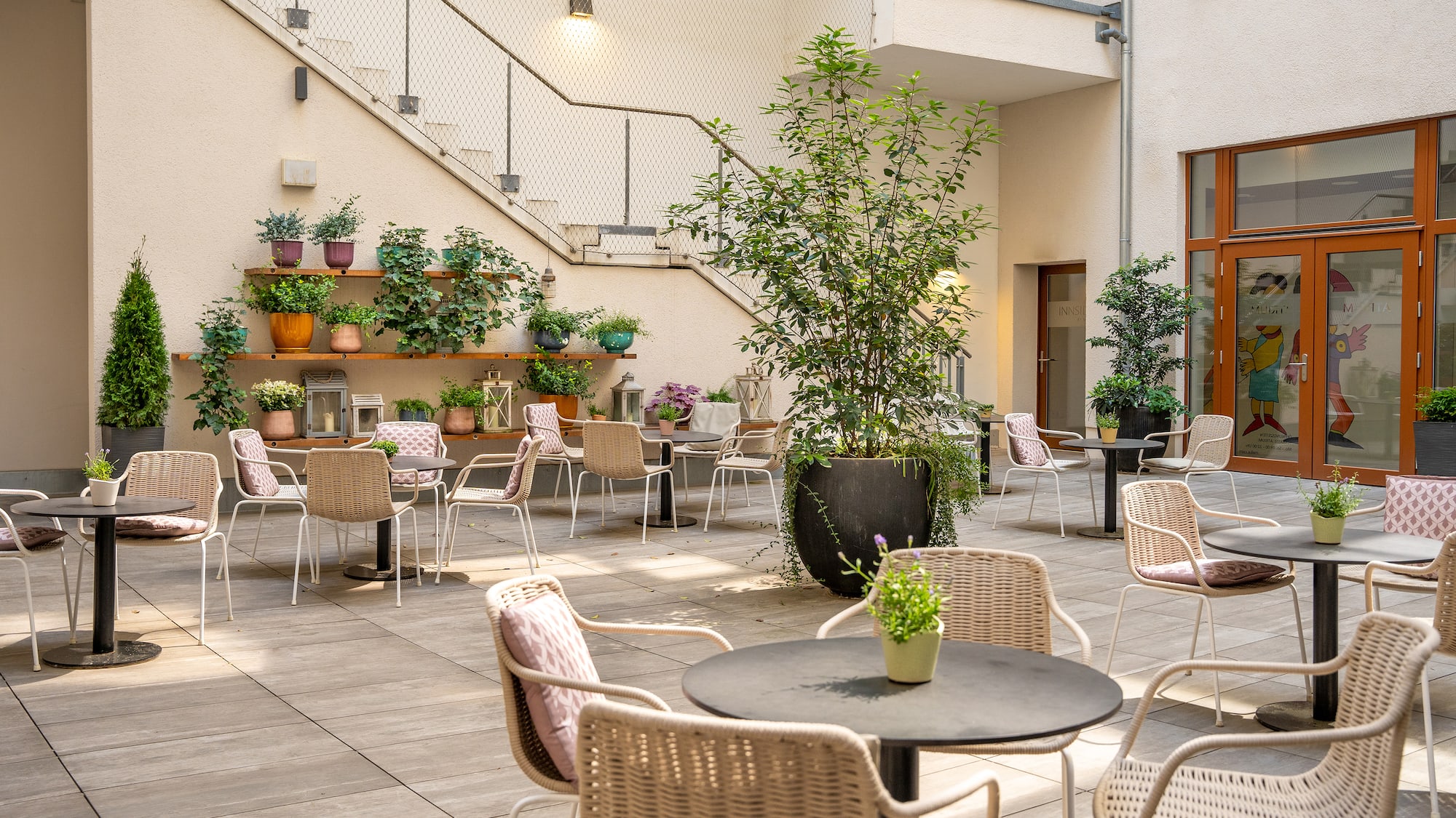 a patio with chairs and tables and plants