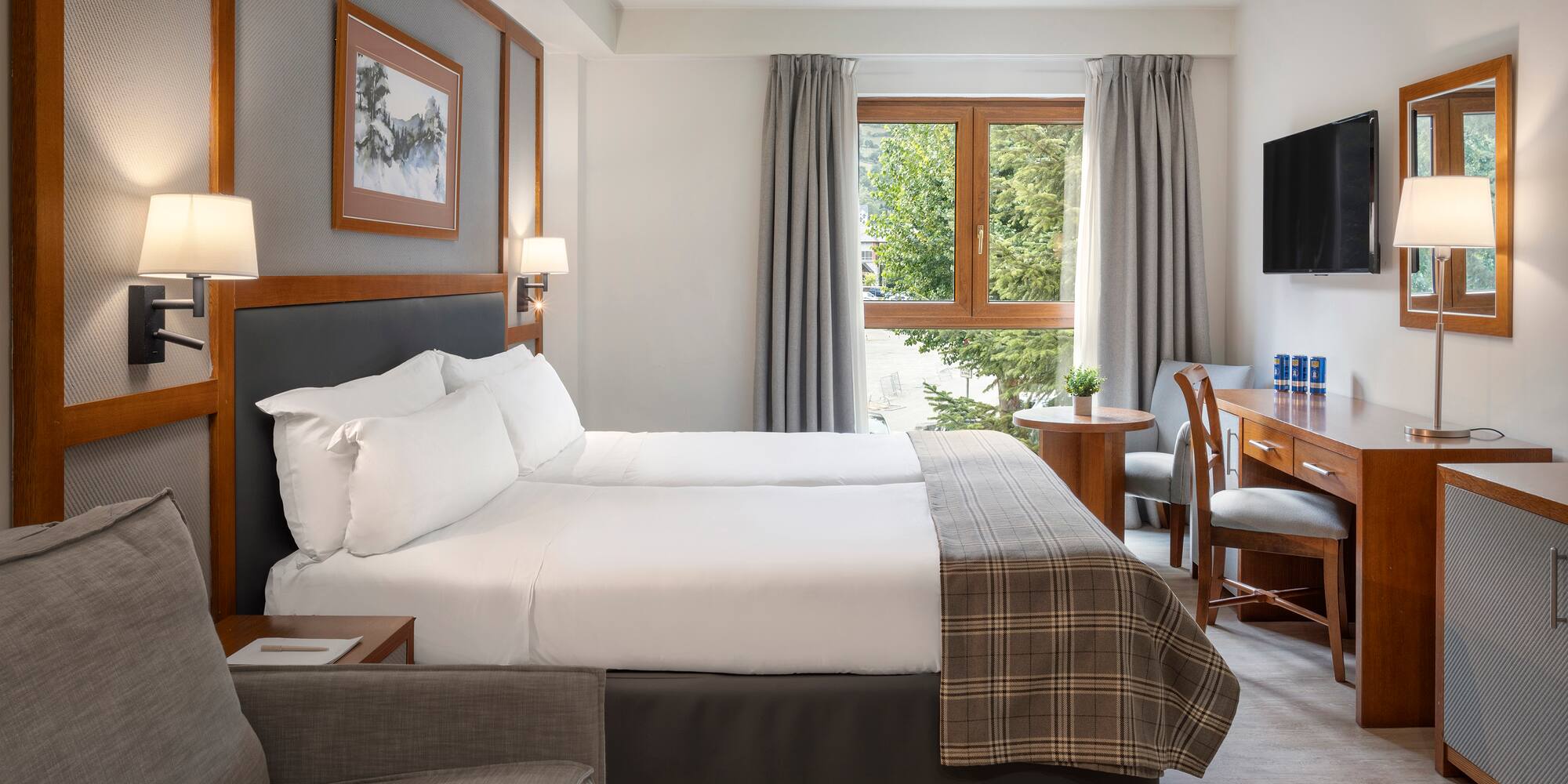 a room with two beds and a desk and chair