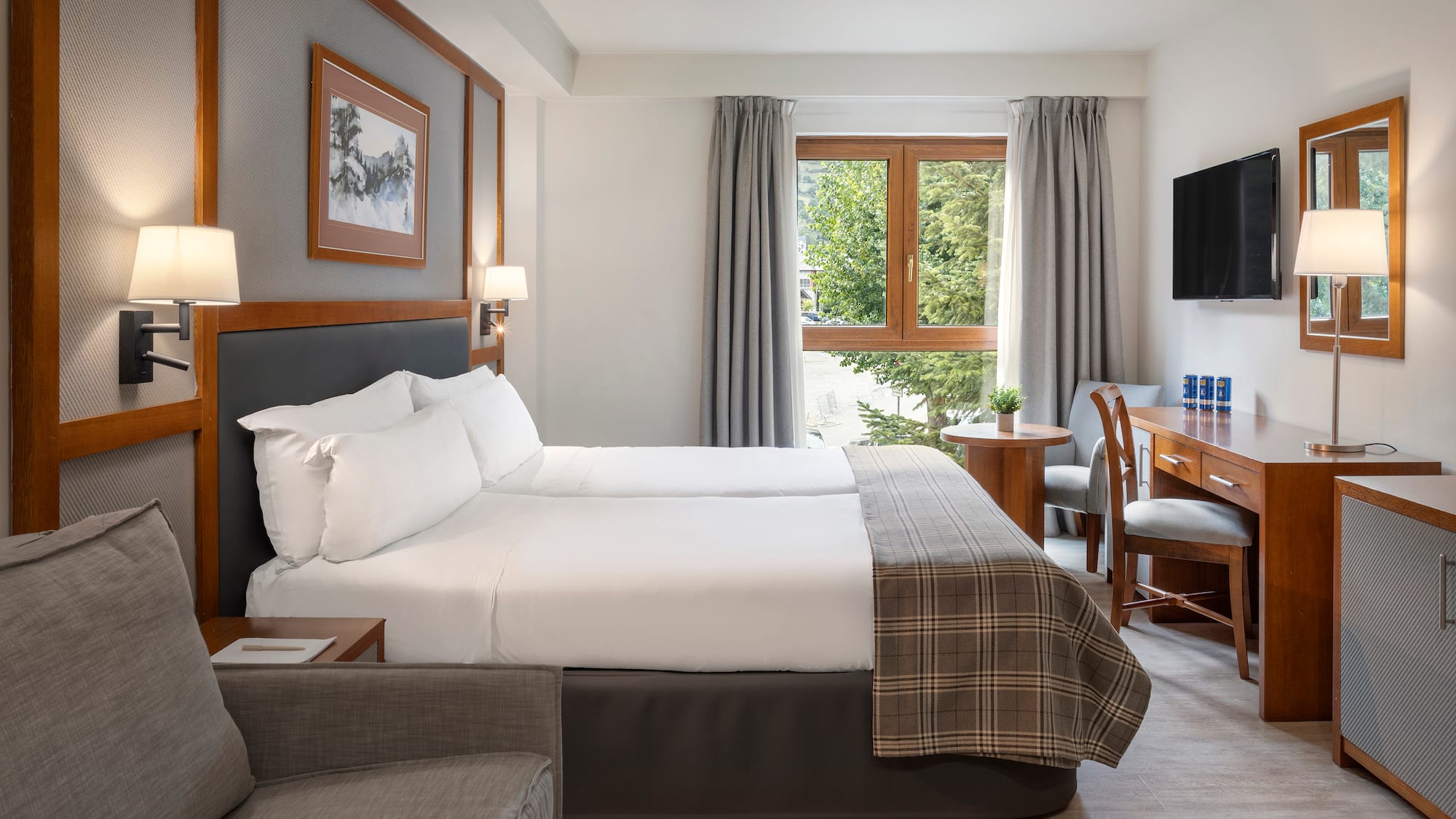 a room with two beds and a desk and chair