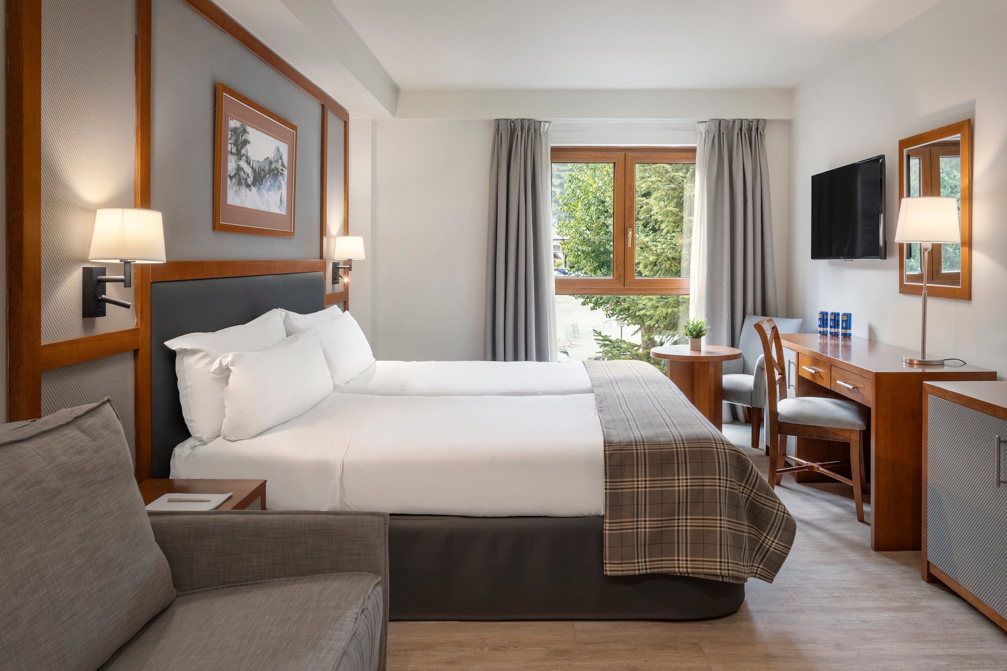 a room with two beds and a desk and chair