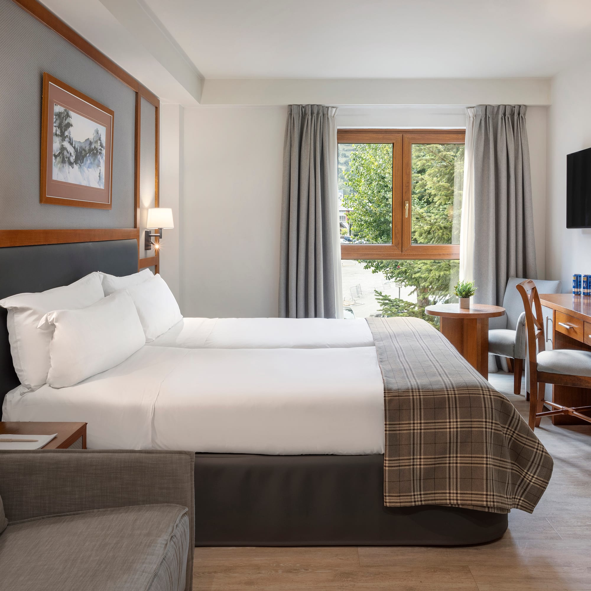 a room with two beds and a desk and chair