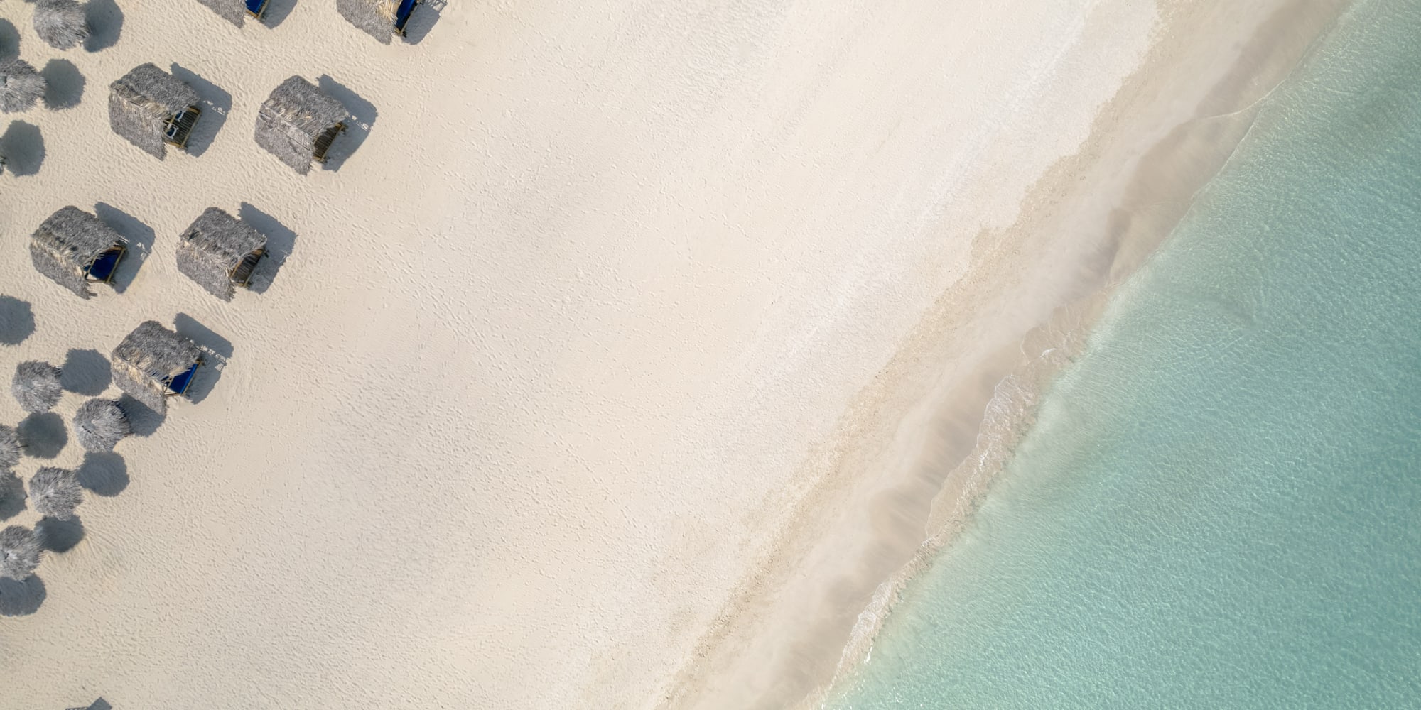 a beach with umbrellas and water