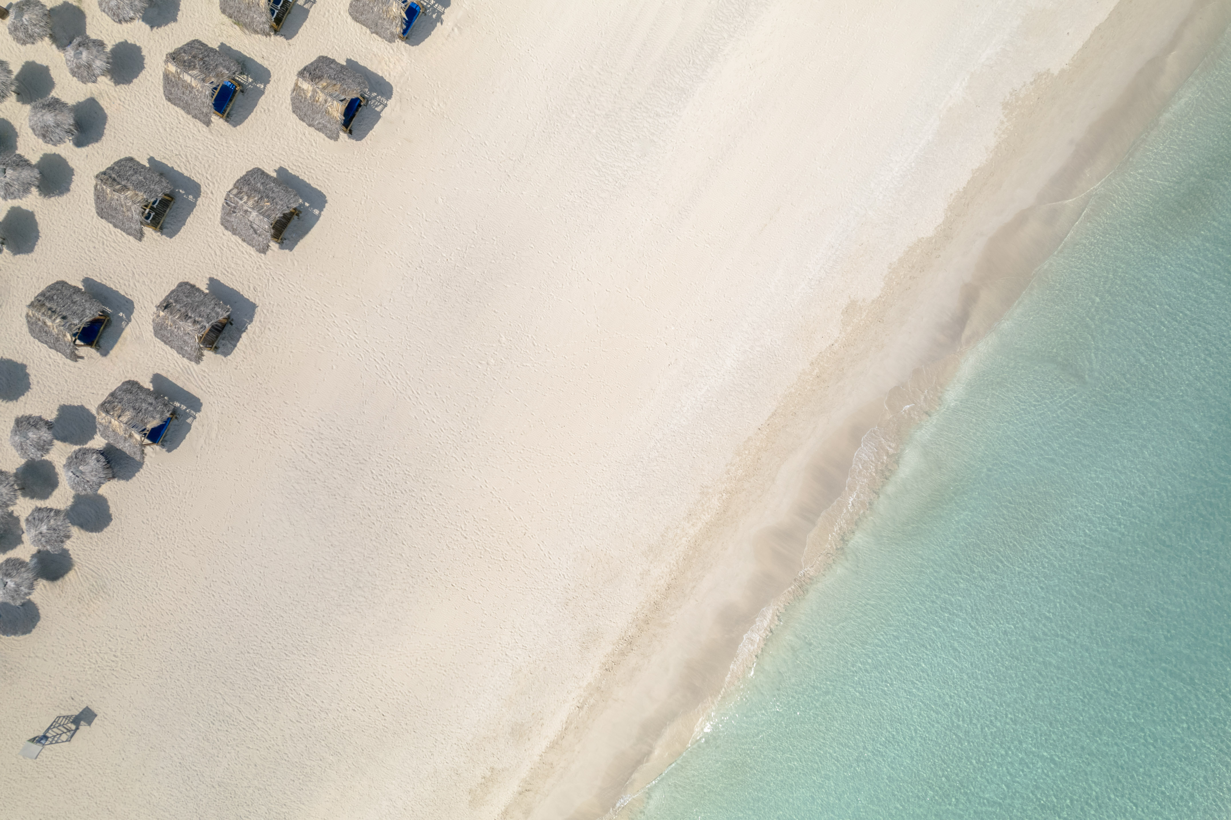 a beach with umbrellas and water