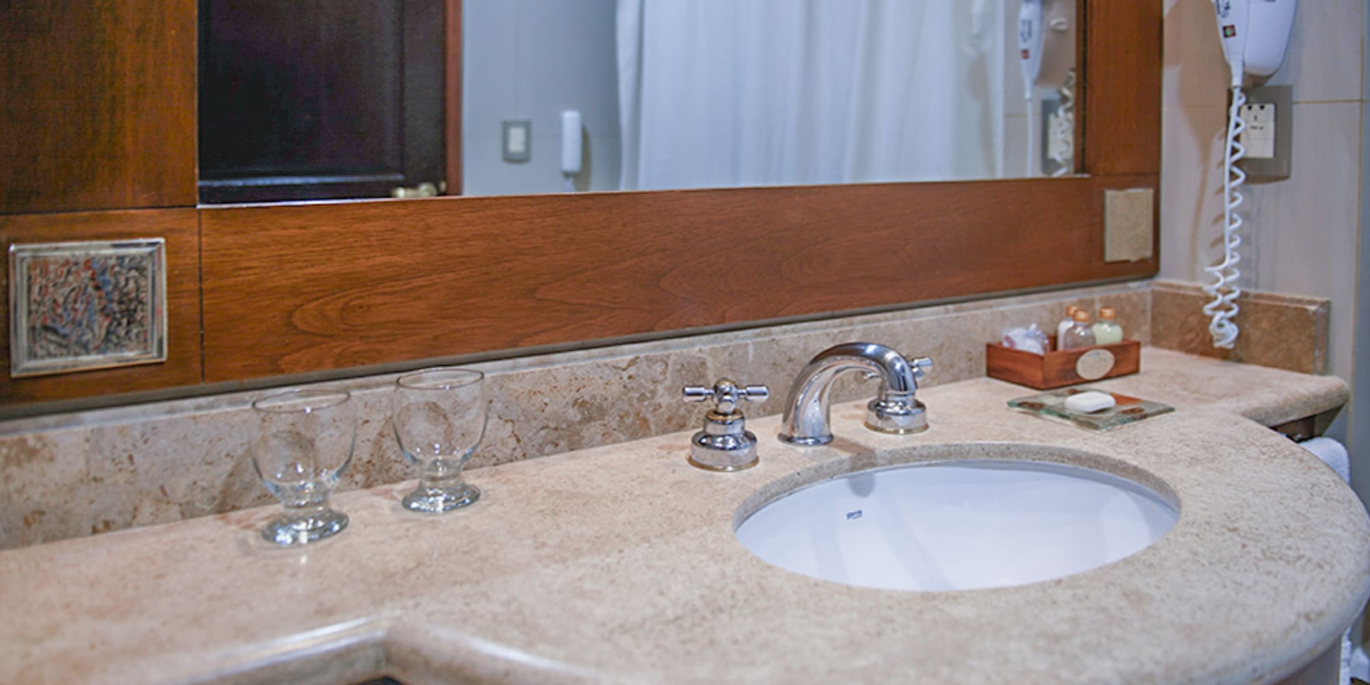 a bathroom sink with wine glasses