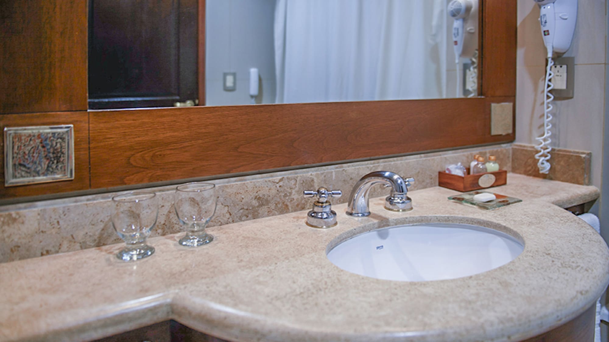 a bathroom sink with wine glasses