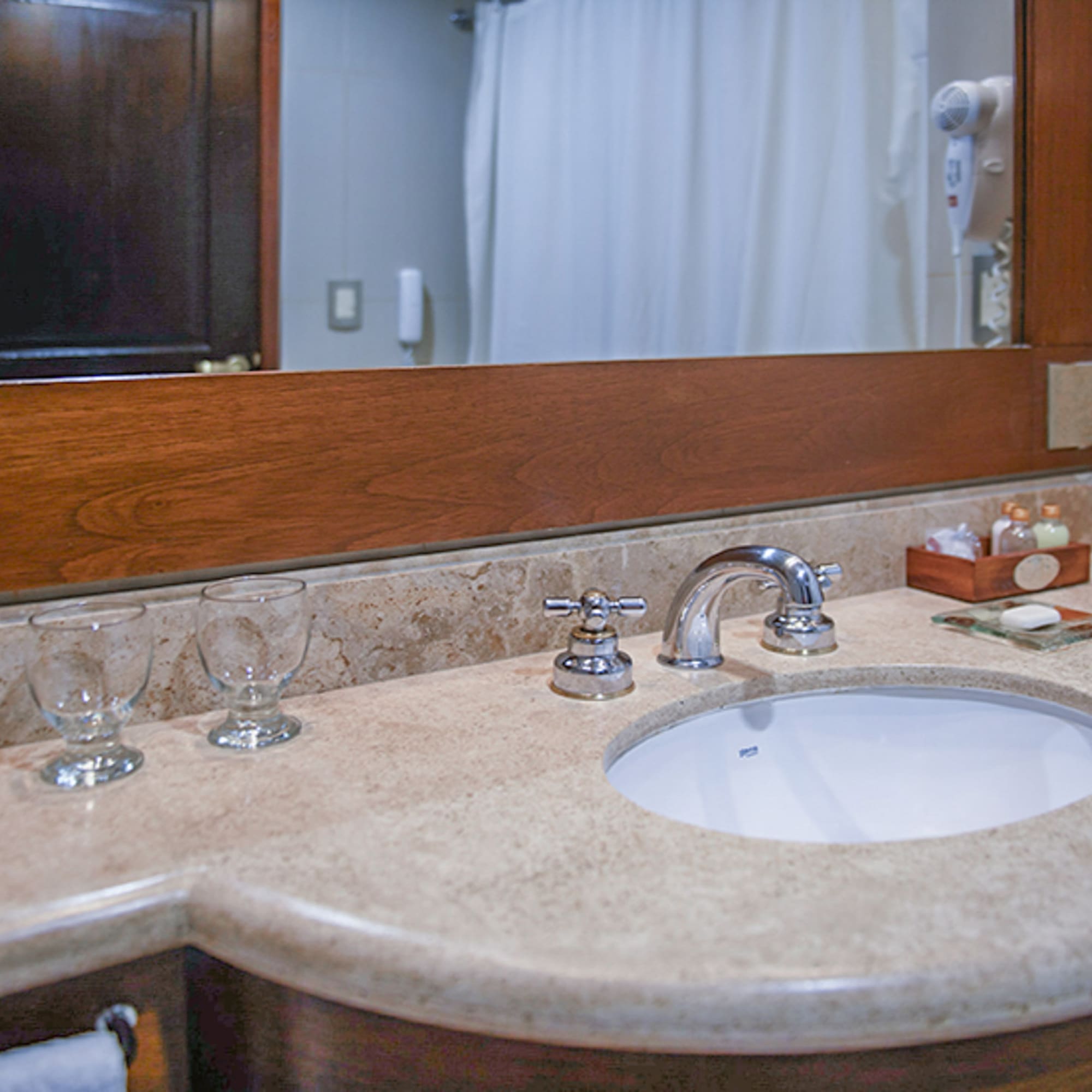 a bathroom sink with wine glasses