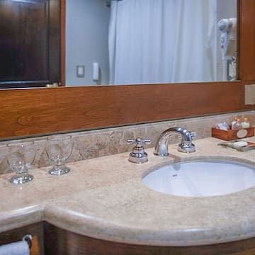 a bathroom sink with wine glasses