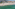 Sunny resort beach with sun loungers, turquoise sea, coastal city, and mountains.