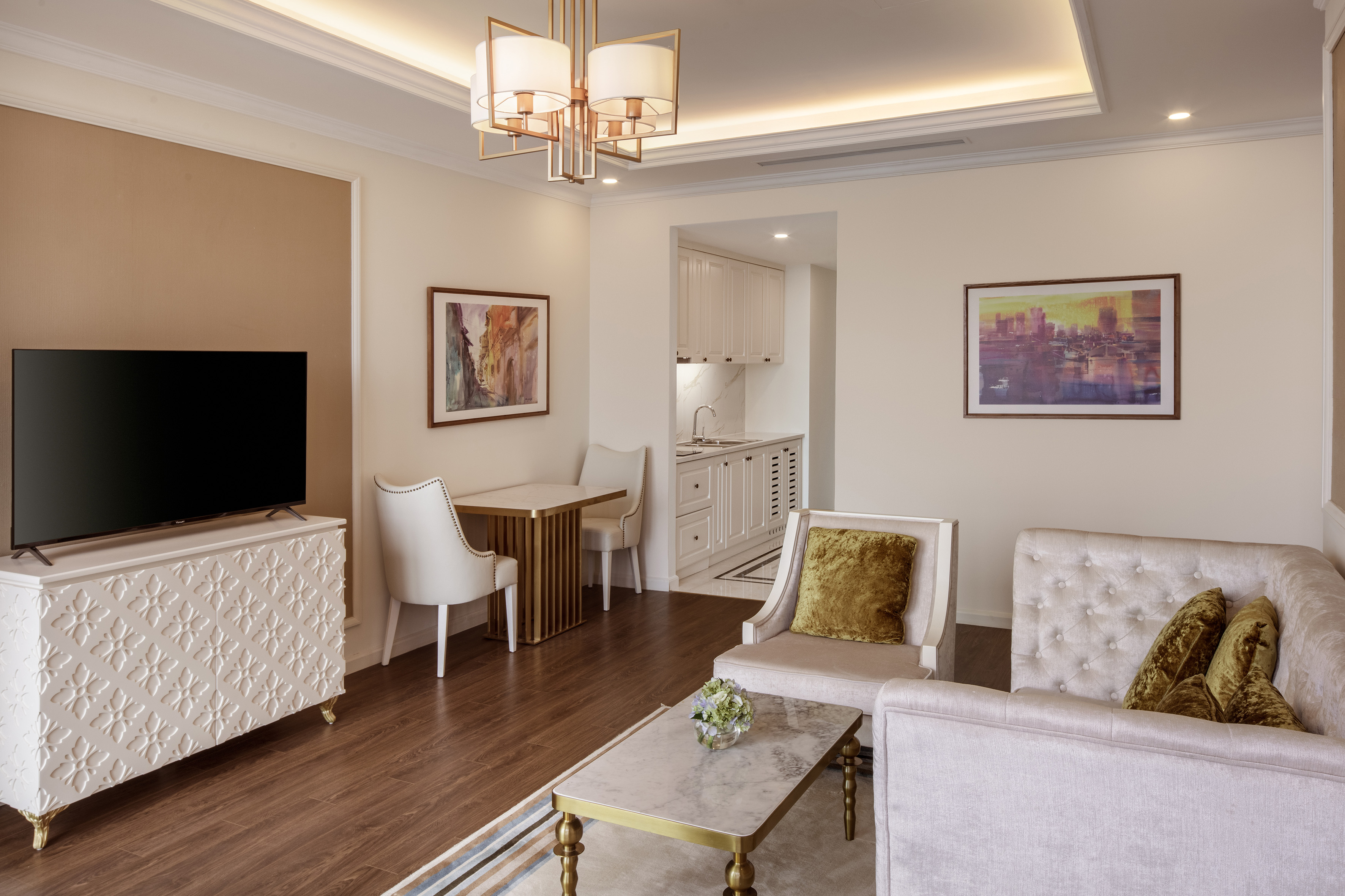 Luxury hotel suite with elegant living room, kitchenette, and dining area.