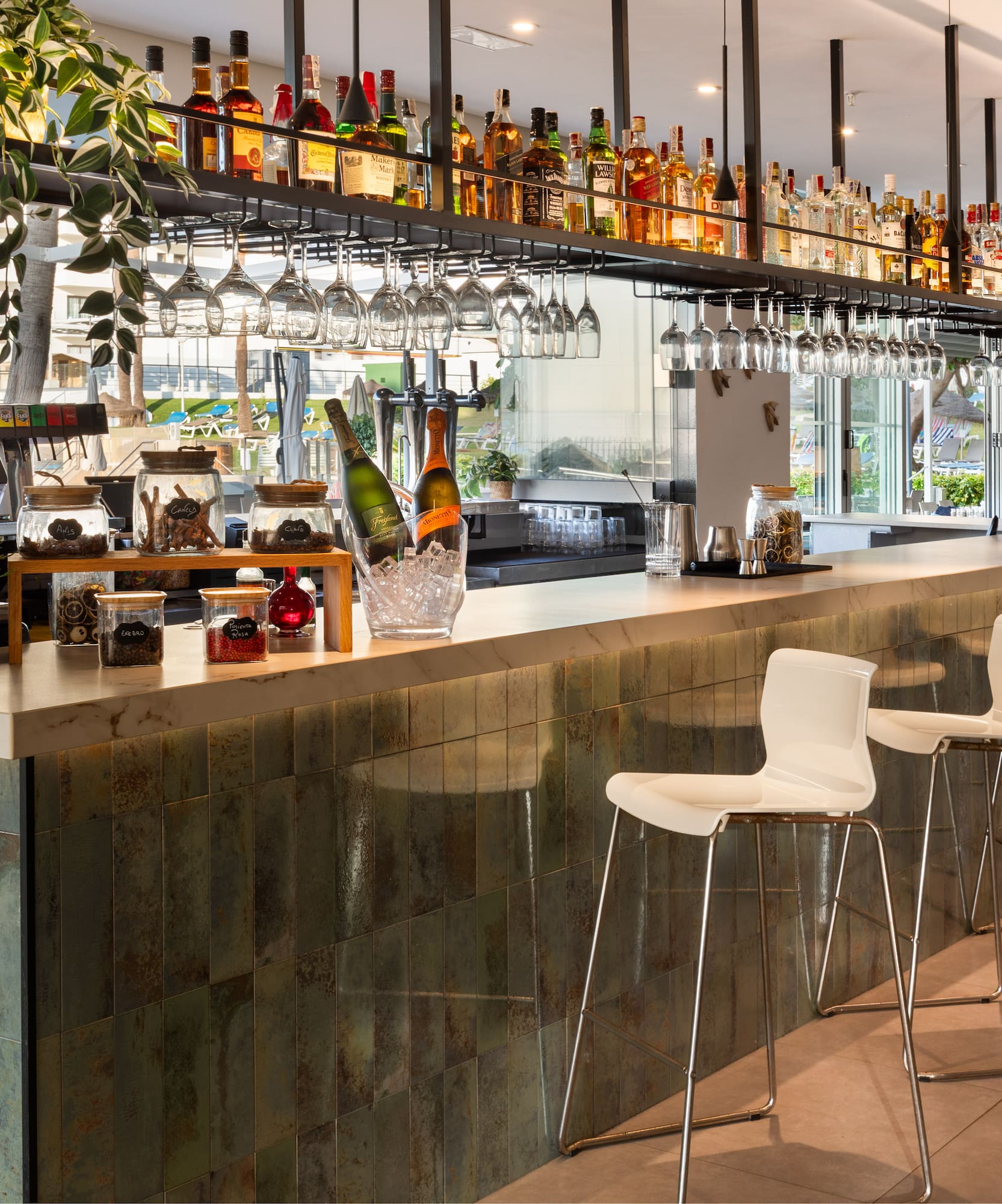 a bar with wine glasses and bottles on top