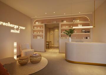 a room with a reception desk and shelves with bottles