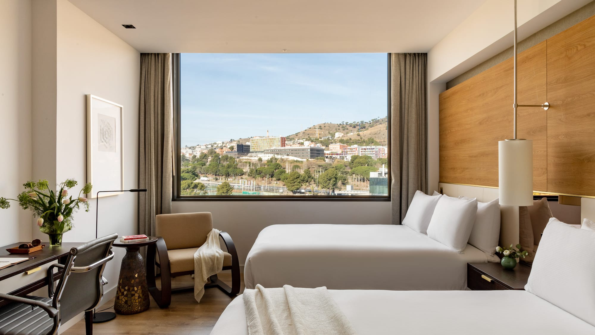 a room with two beds and a large window