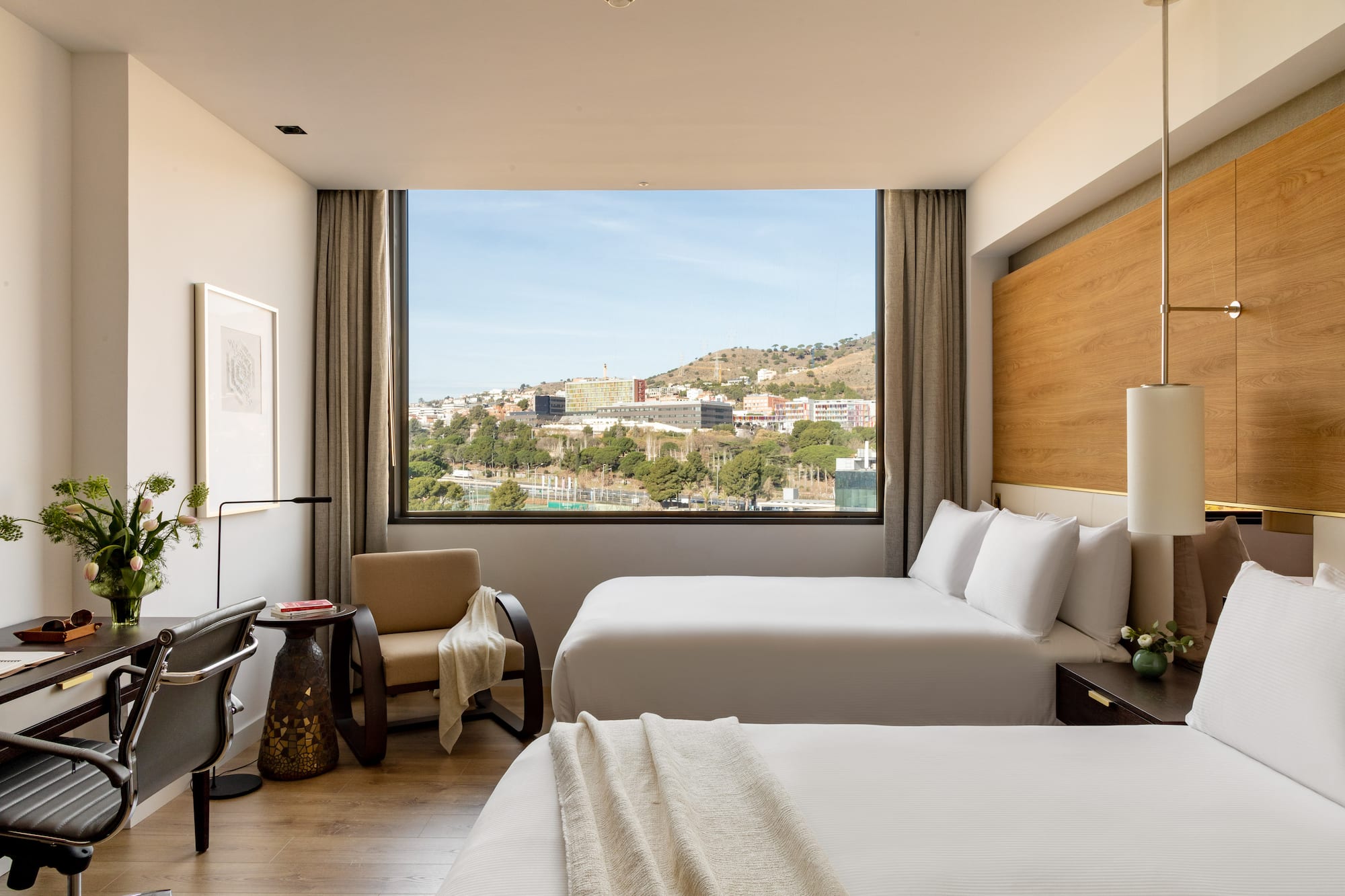 a room with two beds and a large window