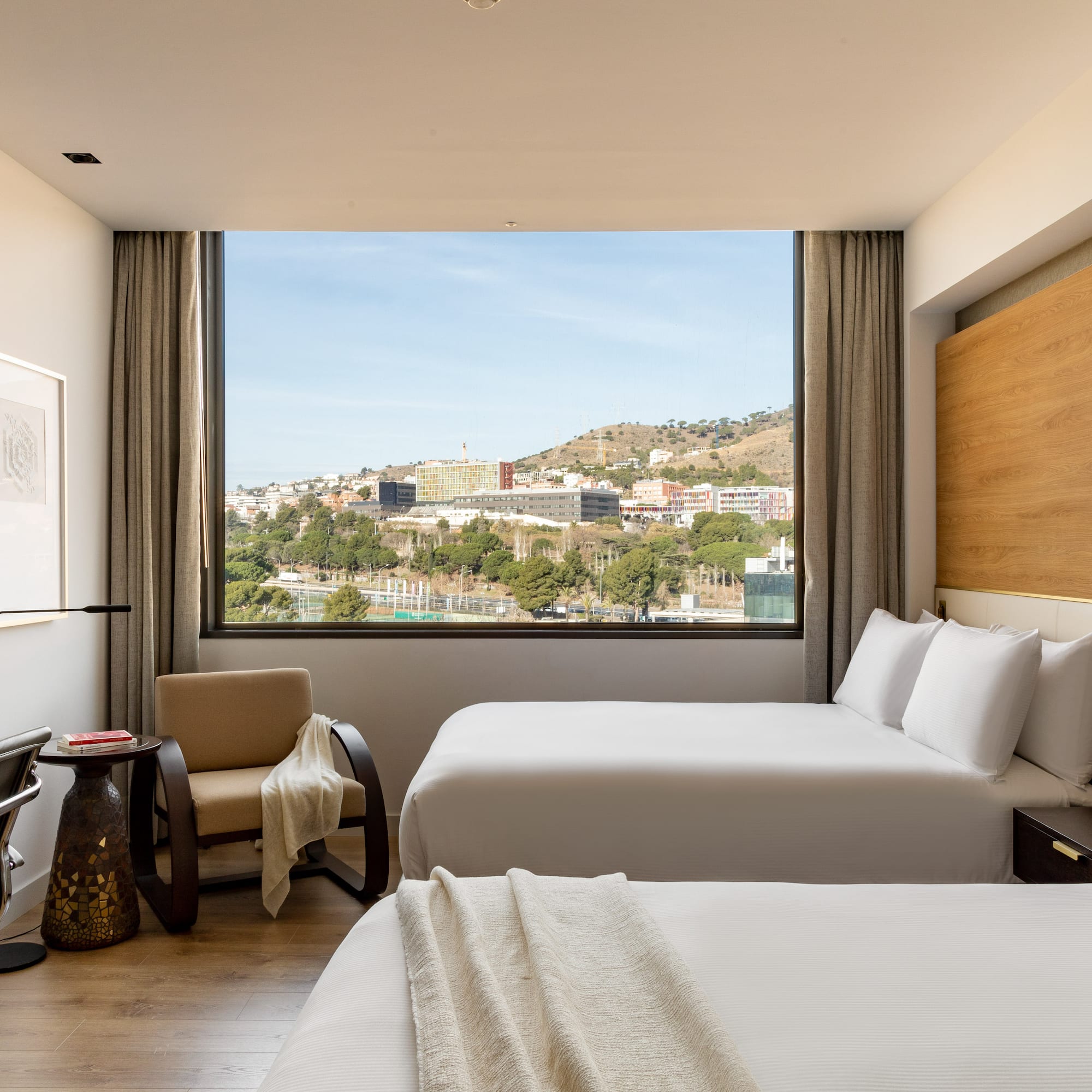 a room with two beds and a large window