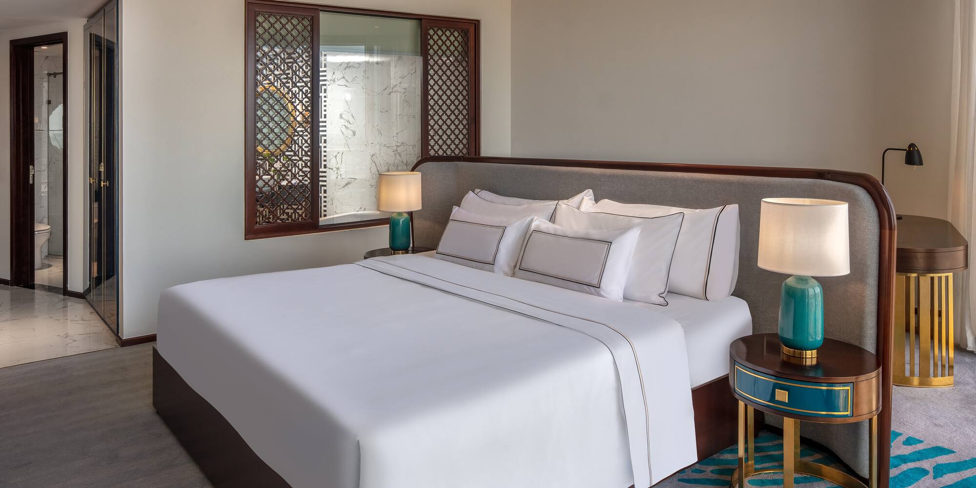 a bed with white sheets and lamps in a room