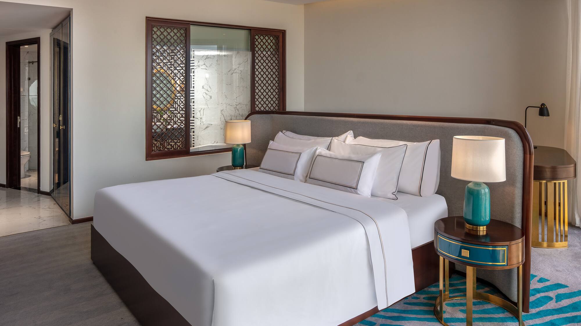 a bed with white sheets and lamps in a room