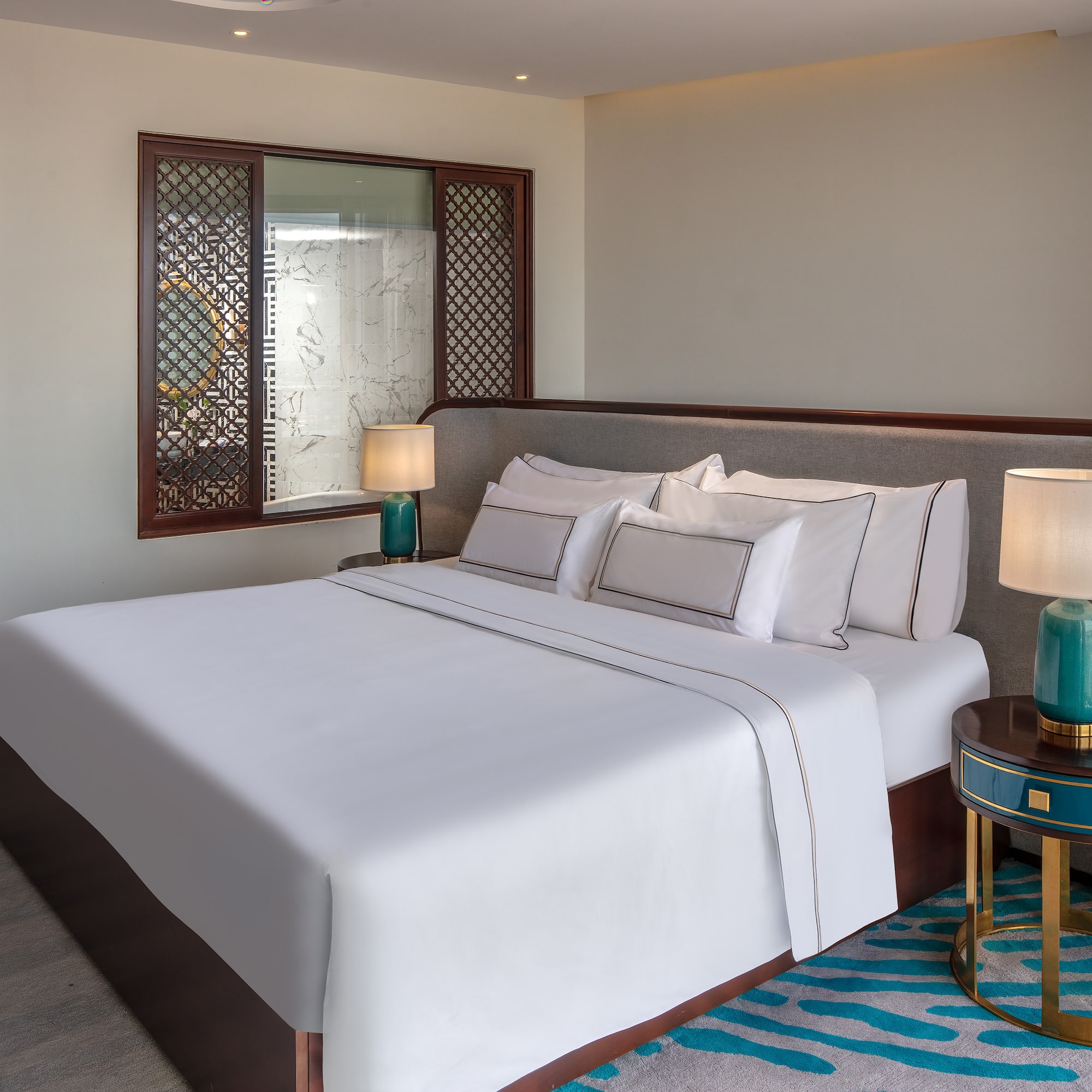 a bed with white sheets and lamps in a room