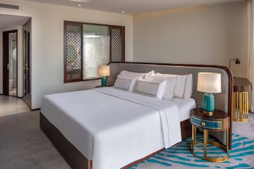 a bed with white sheets and lamps in a room