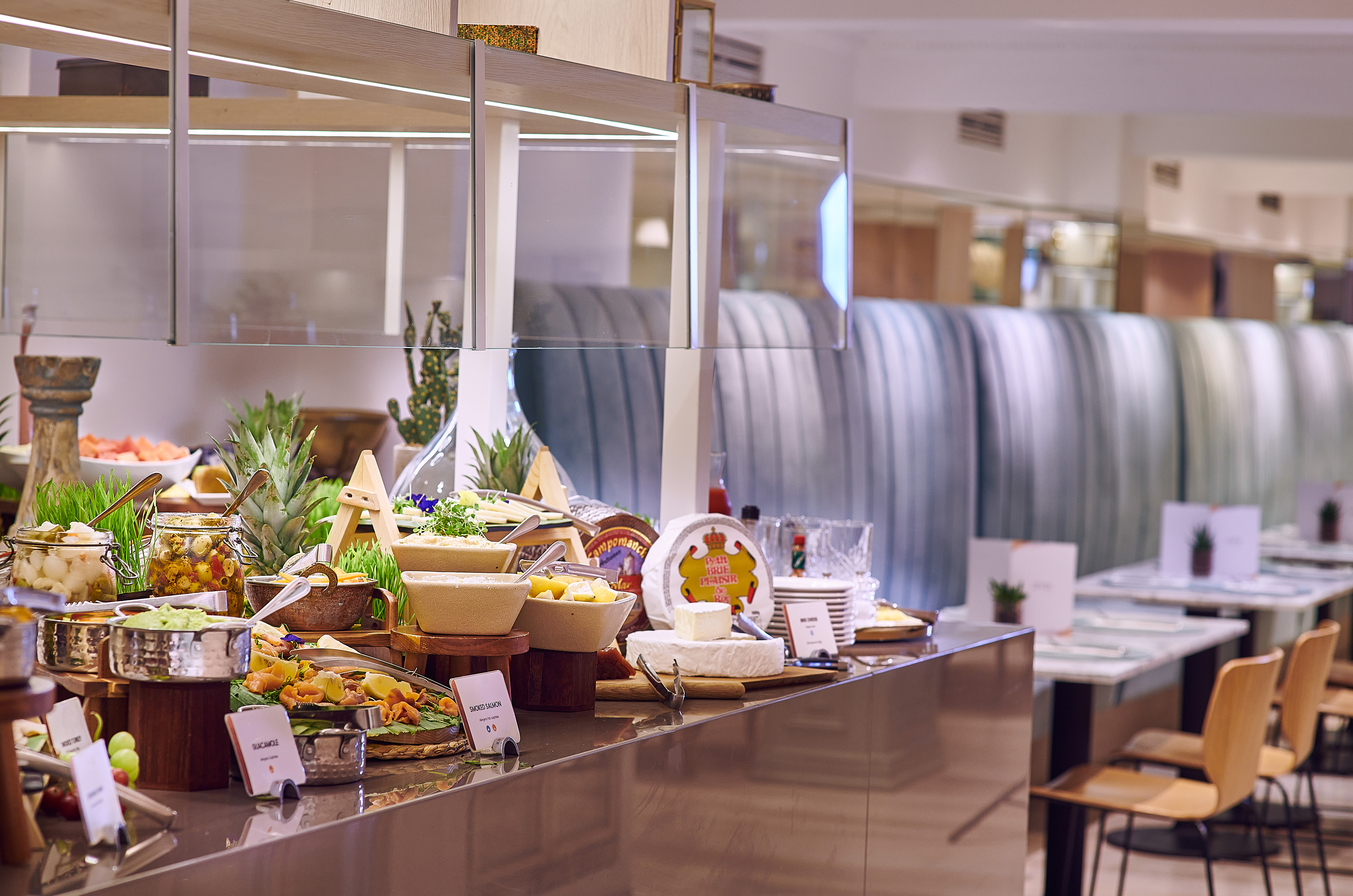 Hotel buffet with cheese, smoked salmon, guacamole, and fresh fruits.