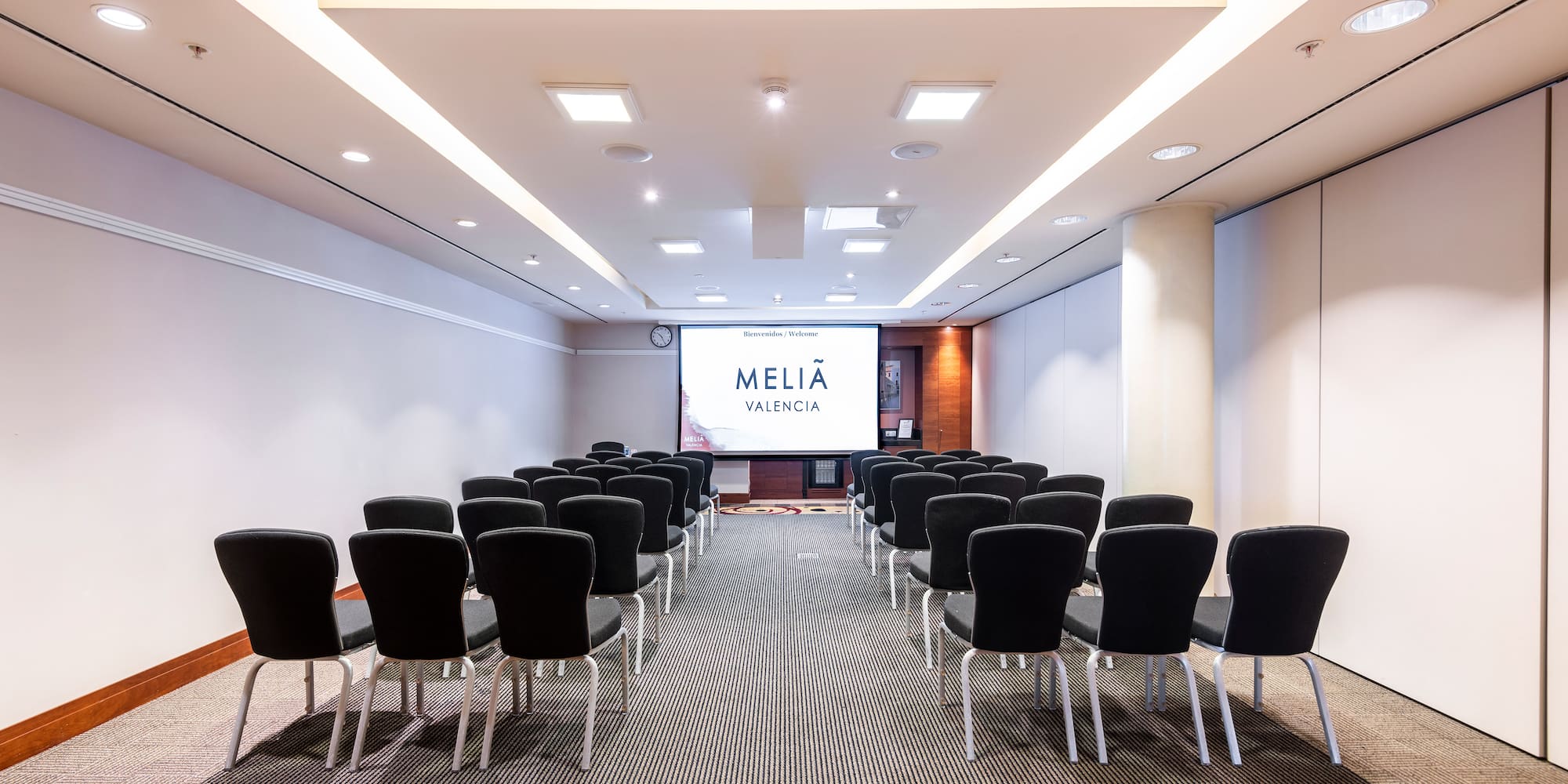 a room with chairs and a projector screen