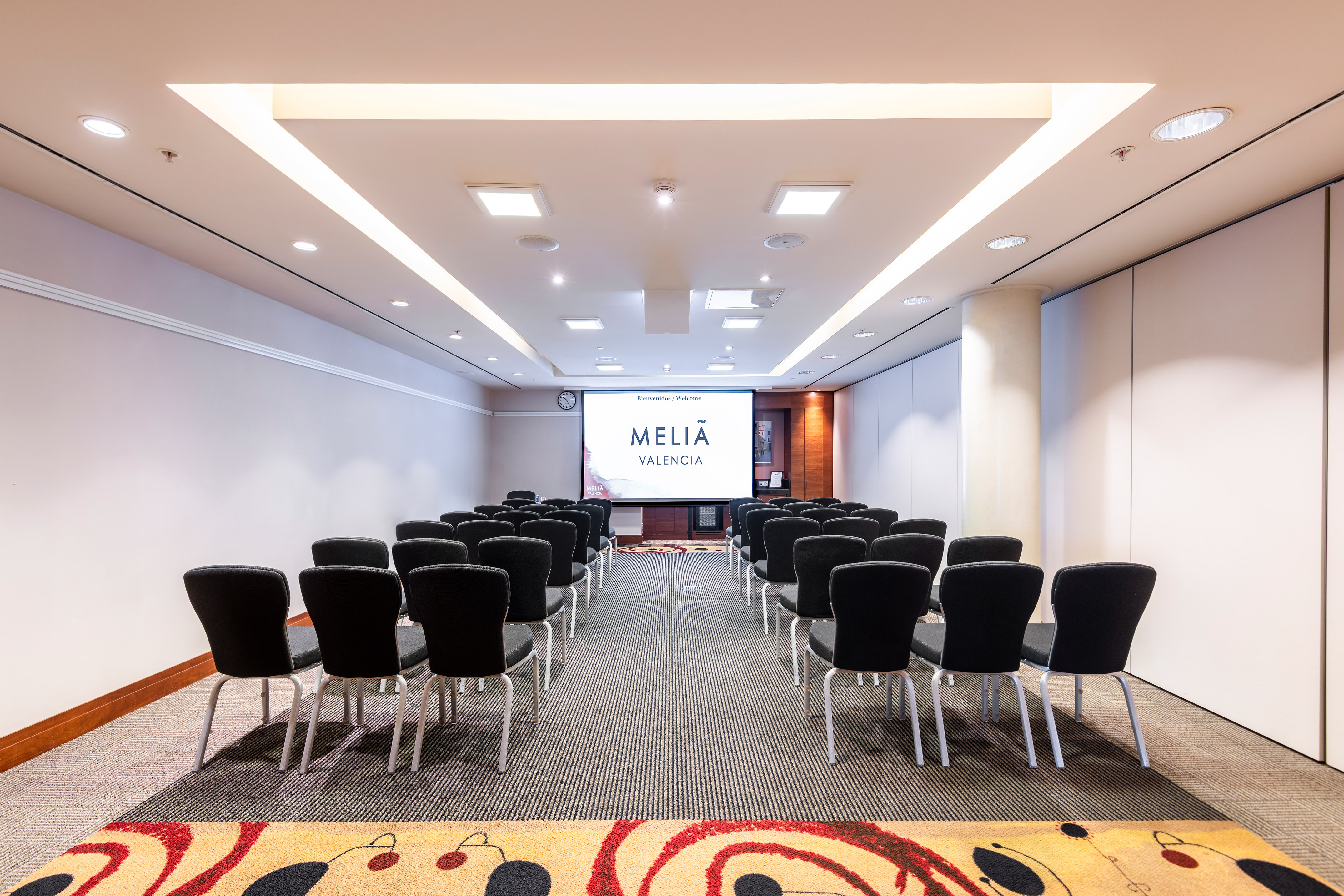 a room with chairs and a projector screen