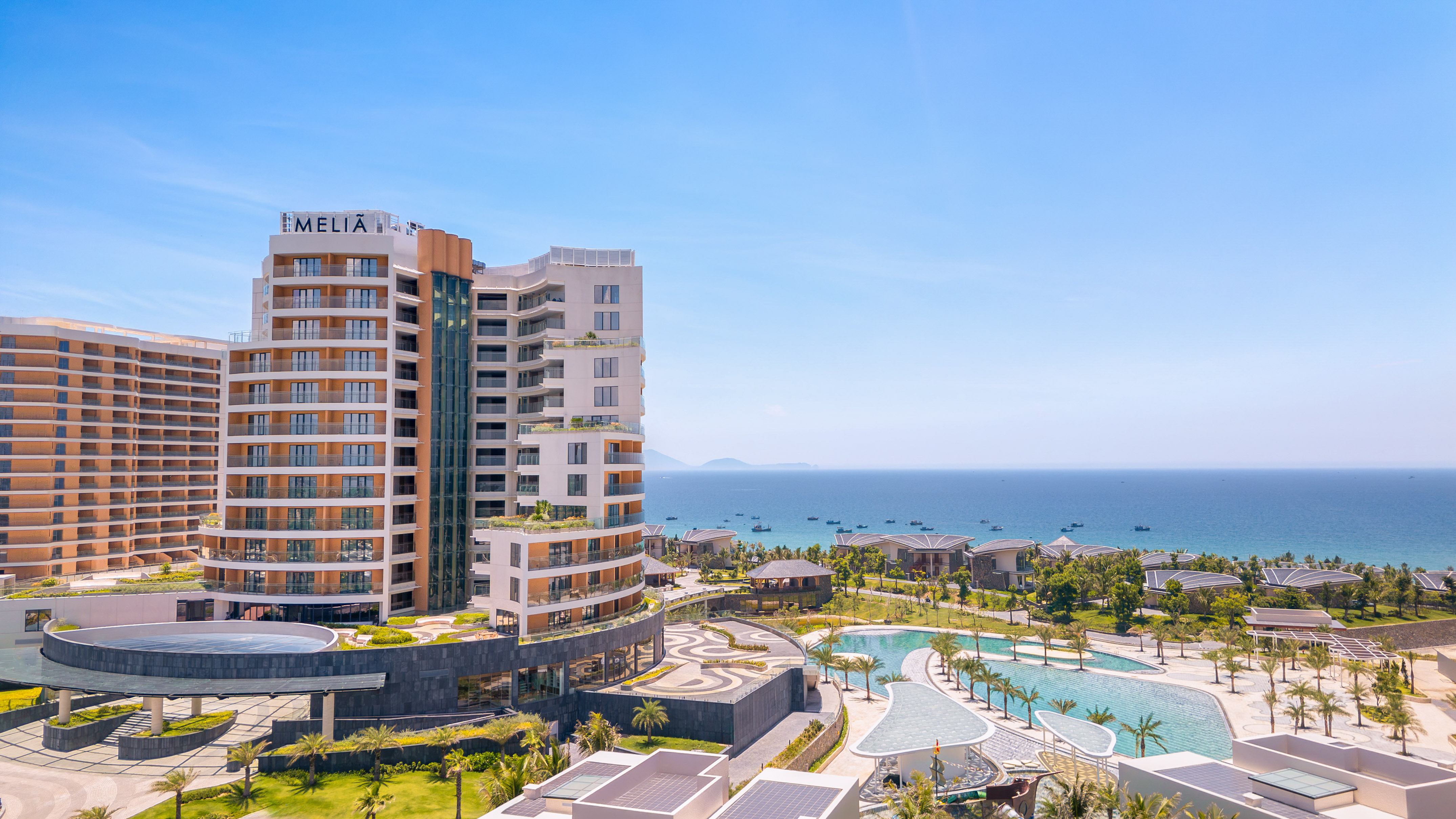 Luxury Melia resort overlooking ocean, pools, and tropical landscaping.