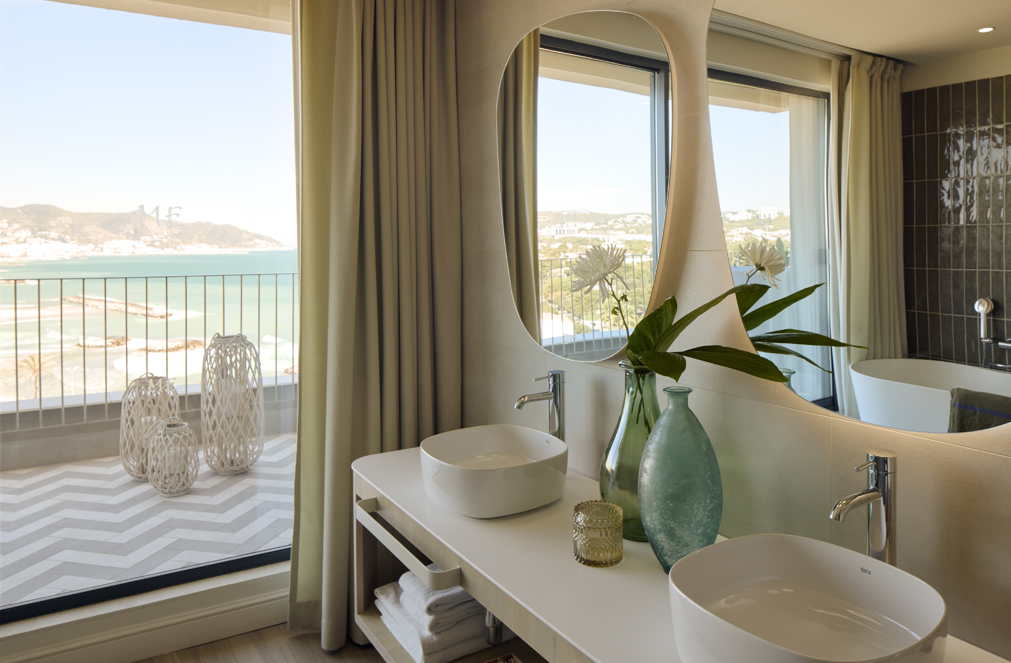 Luxury bathroom with ocean view, modern double sinks, and stylish balcony.