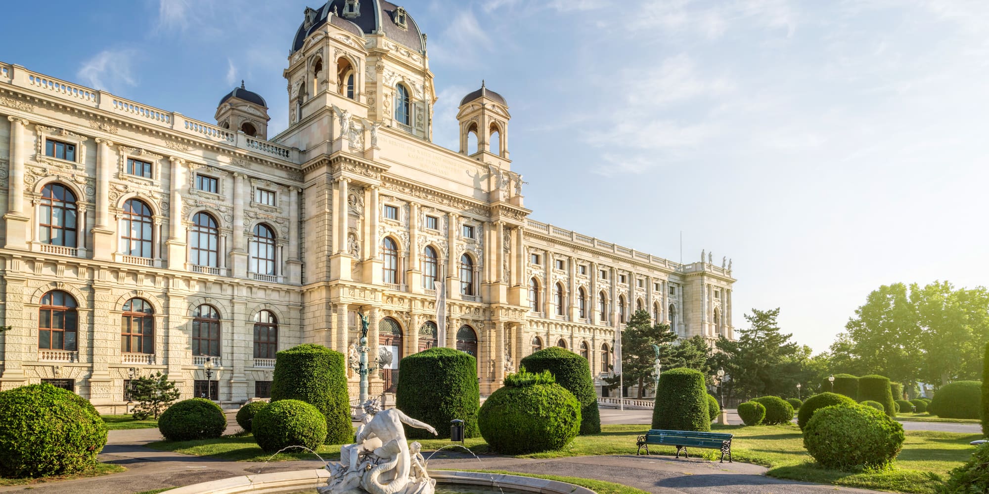 a large white building with a fountain in front of it