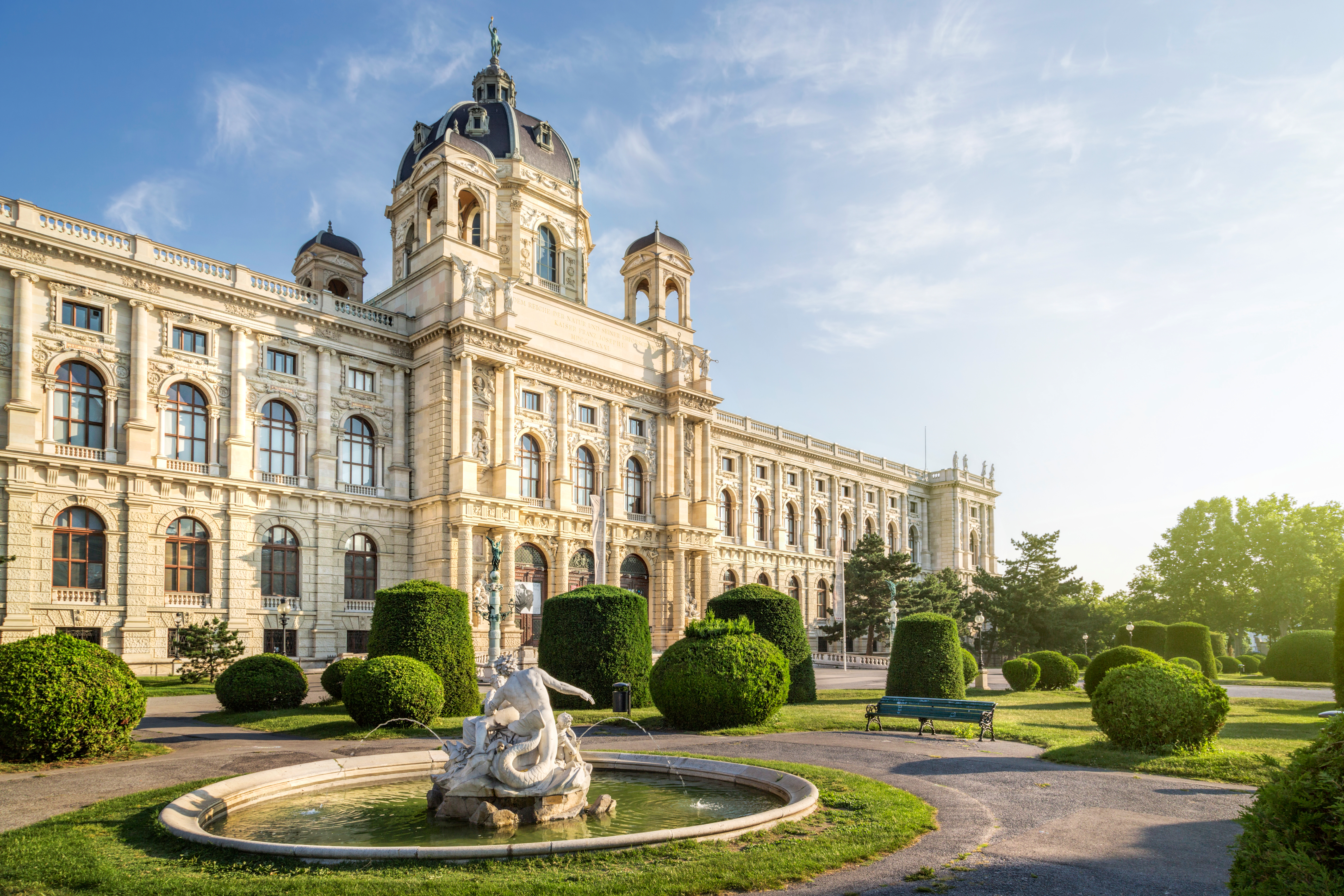 a large white building with a fountain in front of it