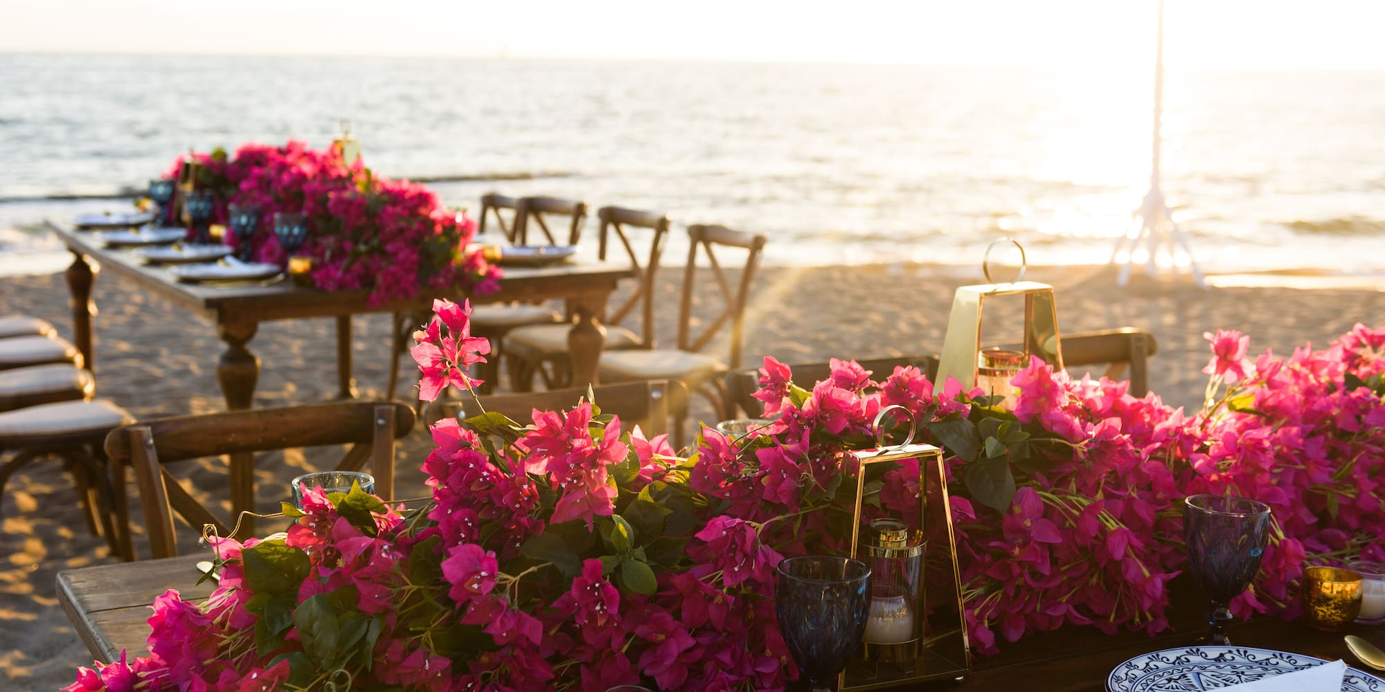 a table set up with pink flowers on it
