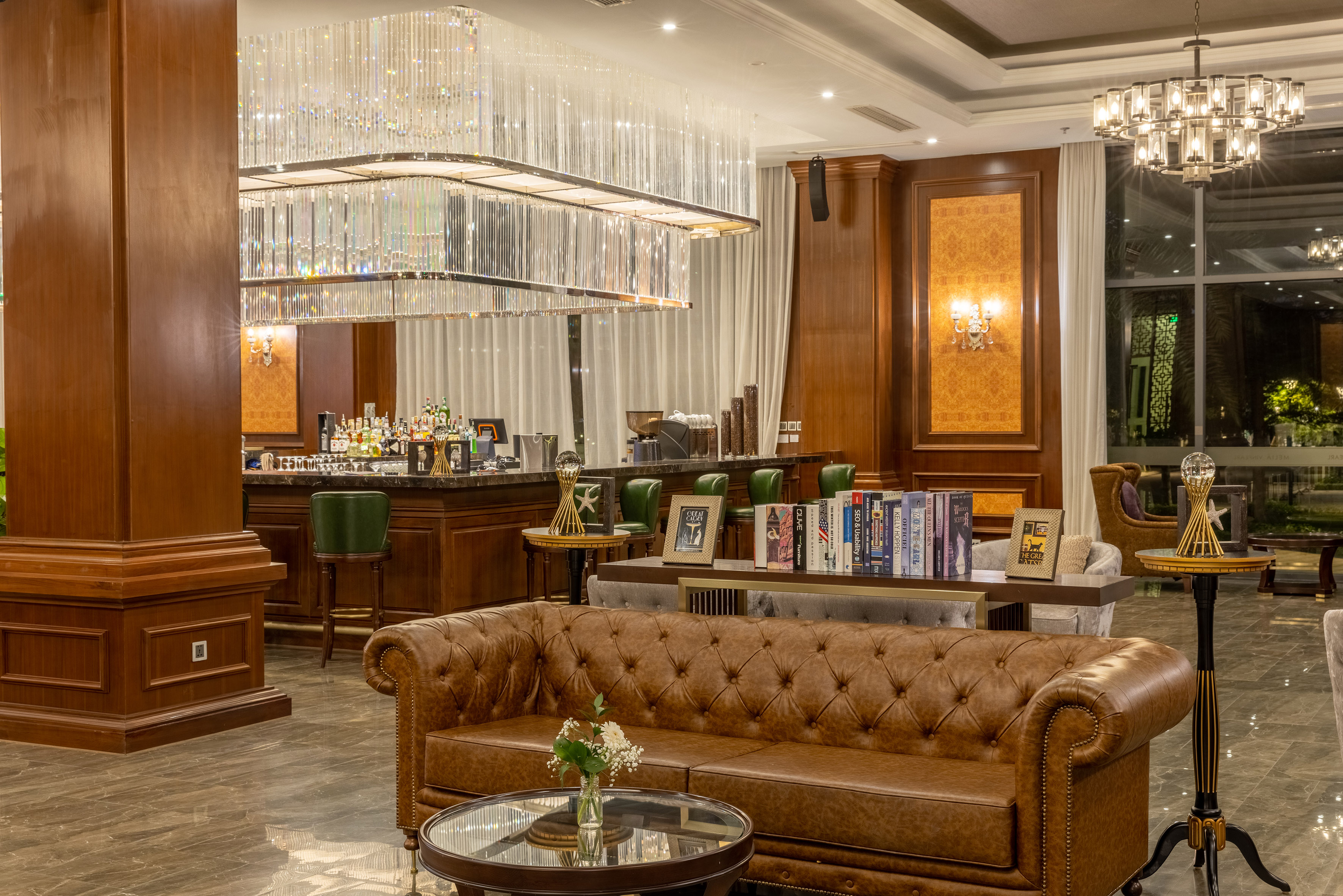 Upscale hotel bar and lounge, crystal chandelier, brown leather sofas.