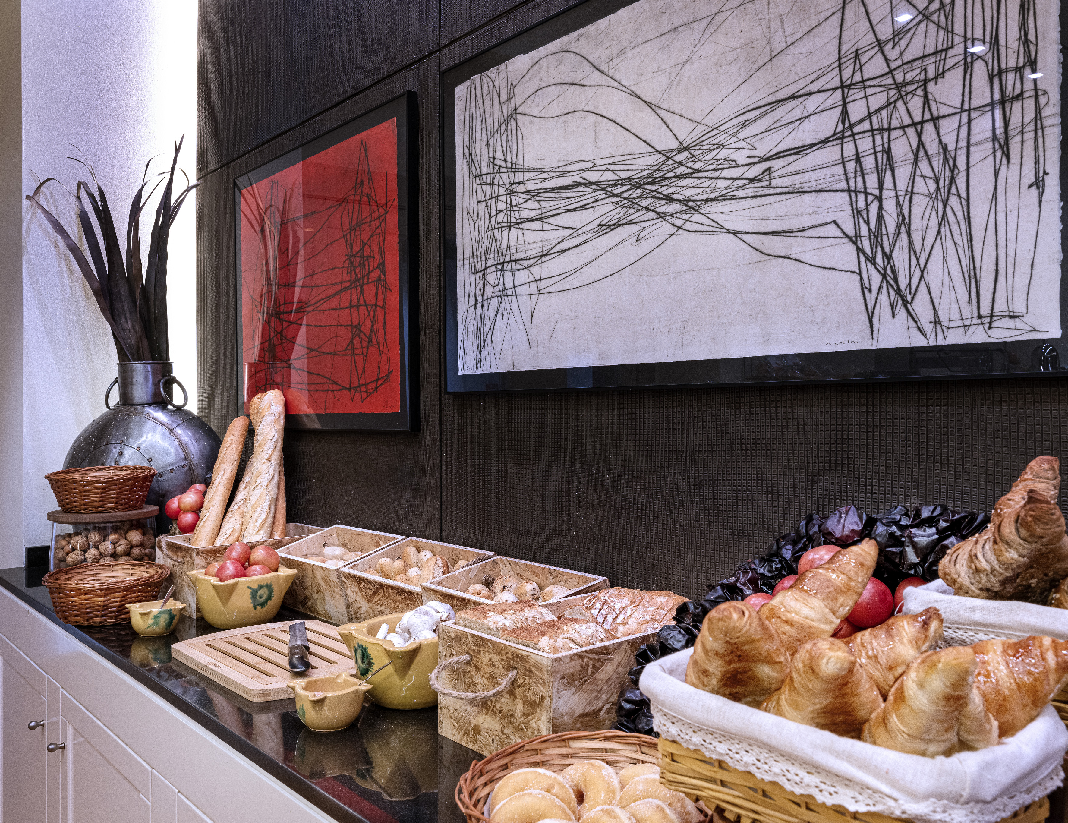 Hotel breakfast buffet with croissants, bread, apples, and nuts.
