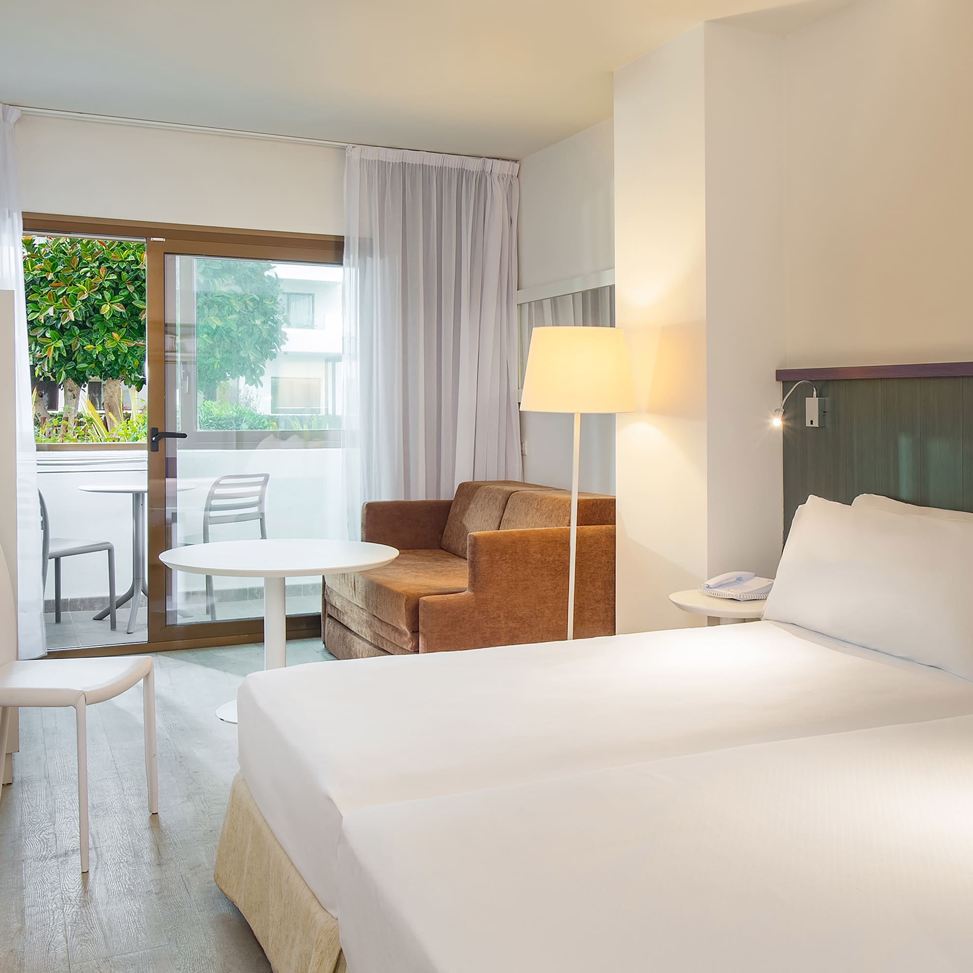 a room with two beds and a chair