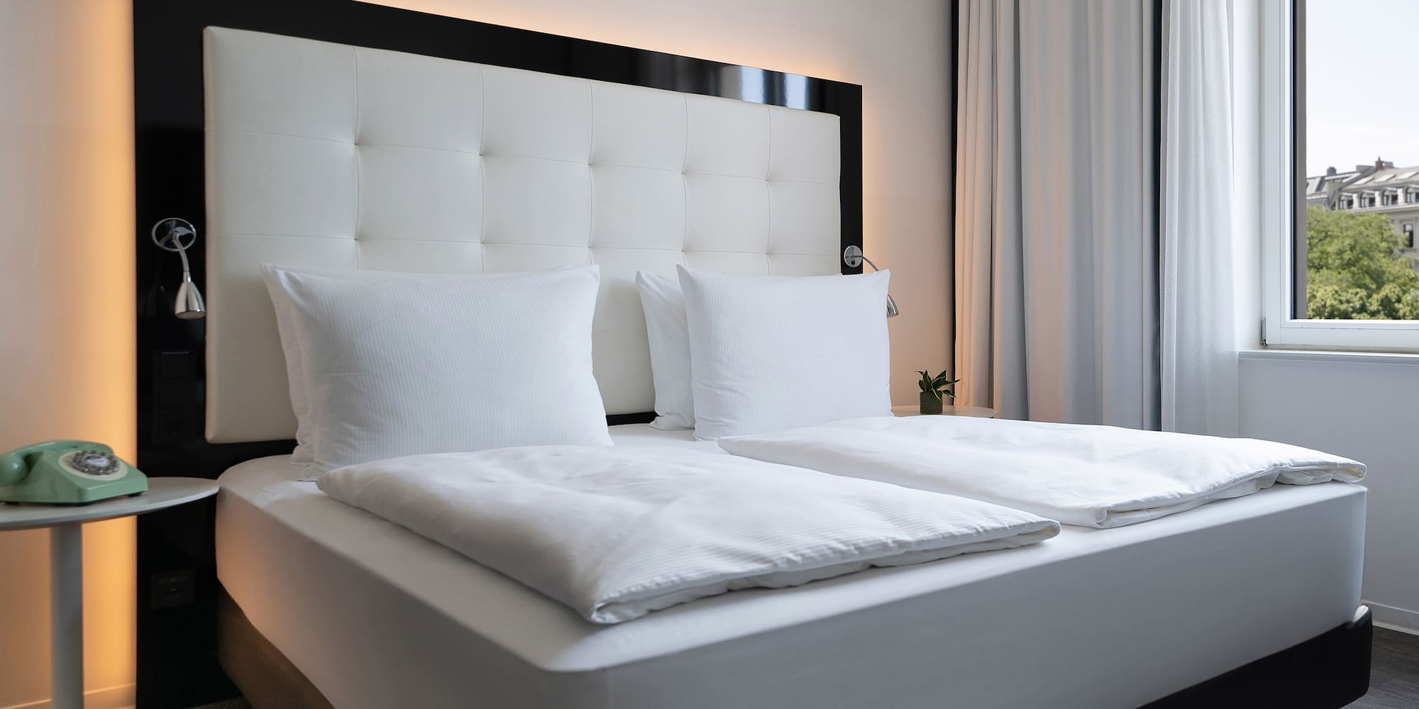 a bed with white sheets and pillows
