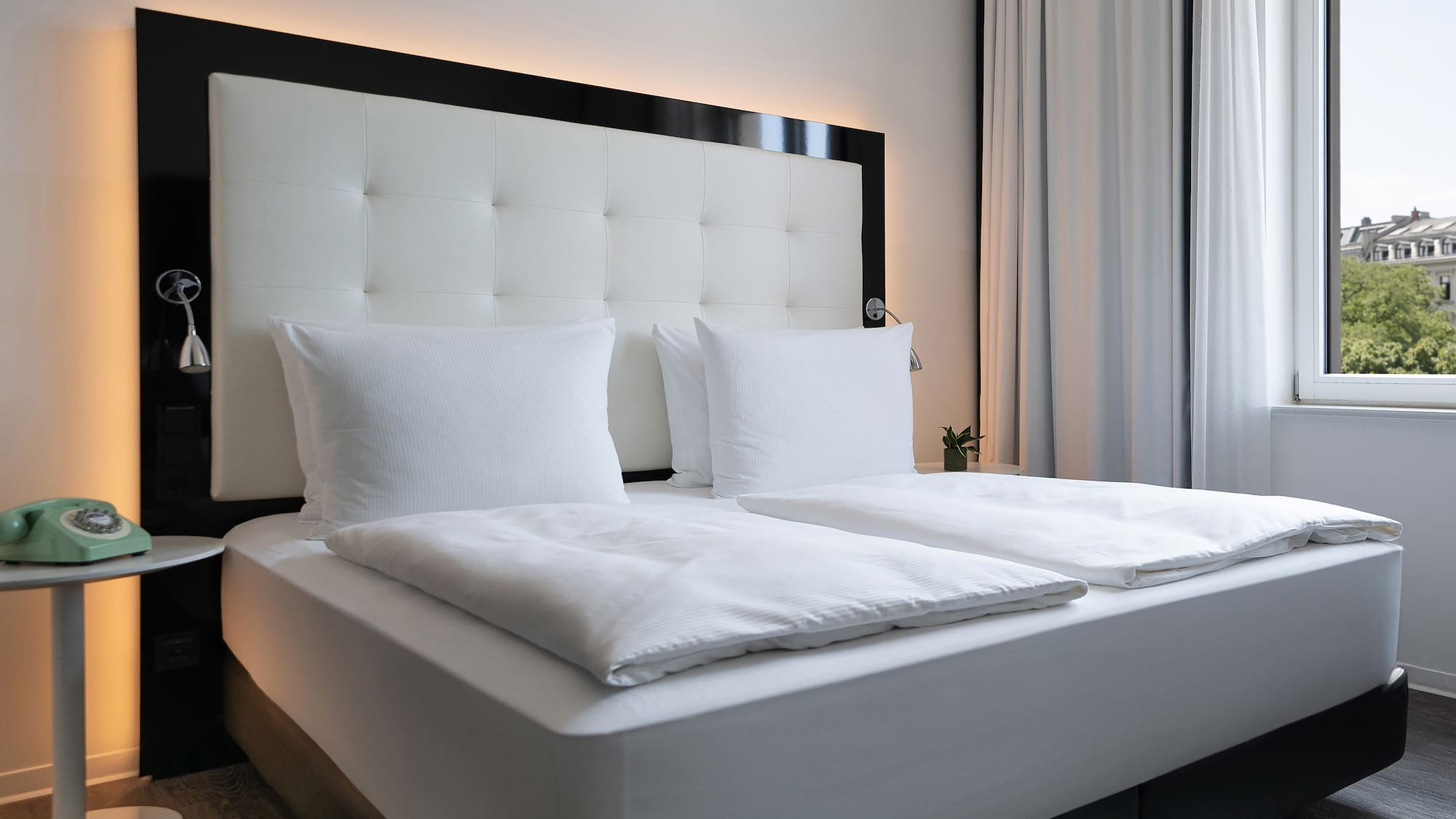 a bed with white sheets and pillows
