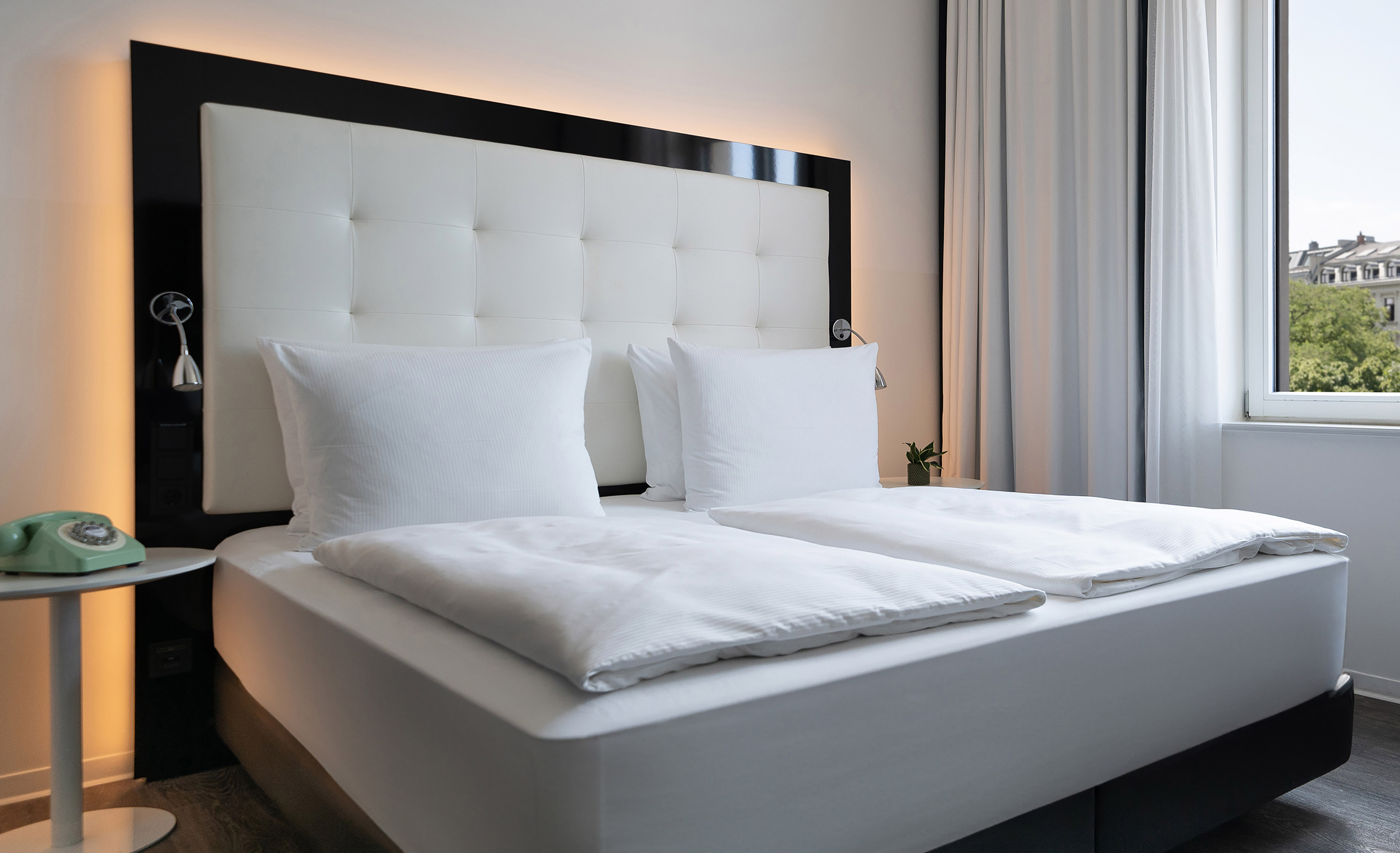 a bed with white sheets and pillows