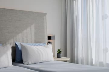 a bed with a plant on the side table