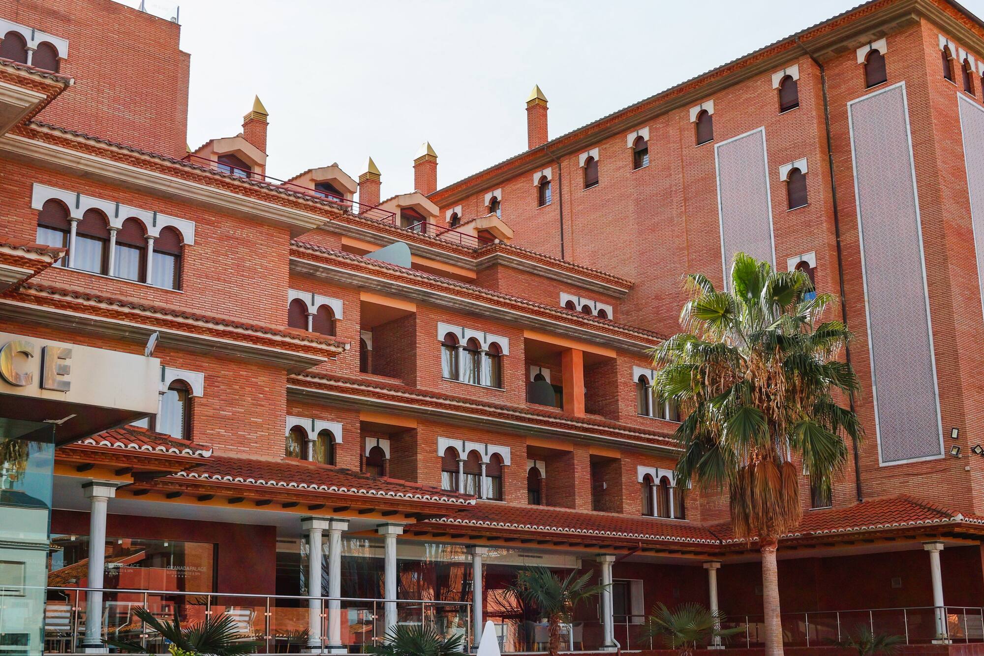 a building with many windows and palm trees