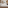 Modern hotel room with bed, city view, daybed, and wood paneling.