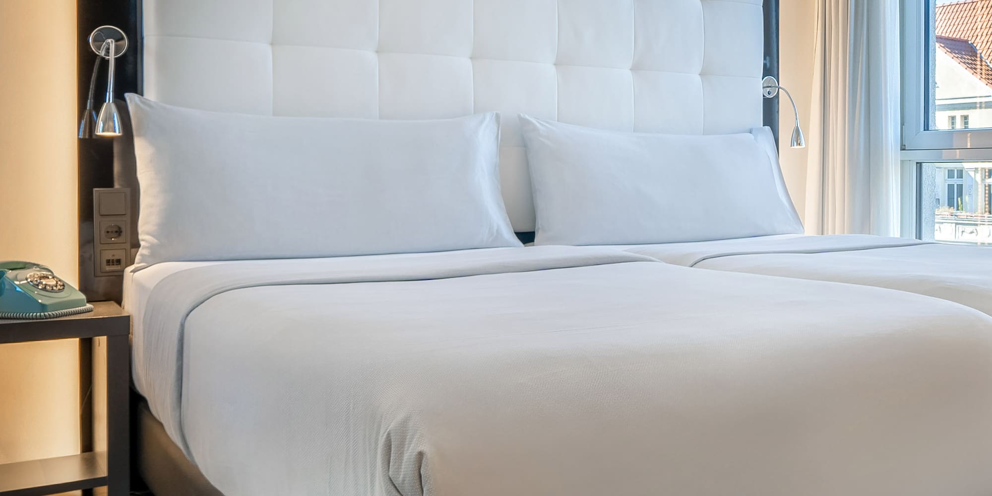 a bed with white sheets and a black headboard