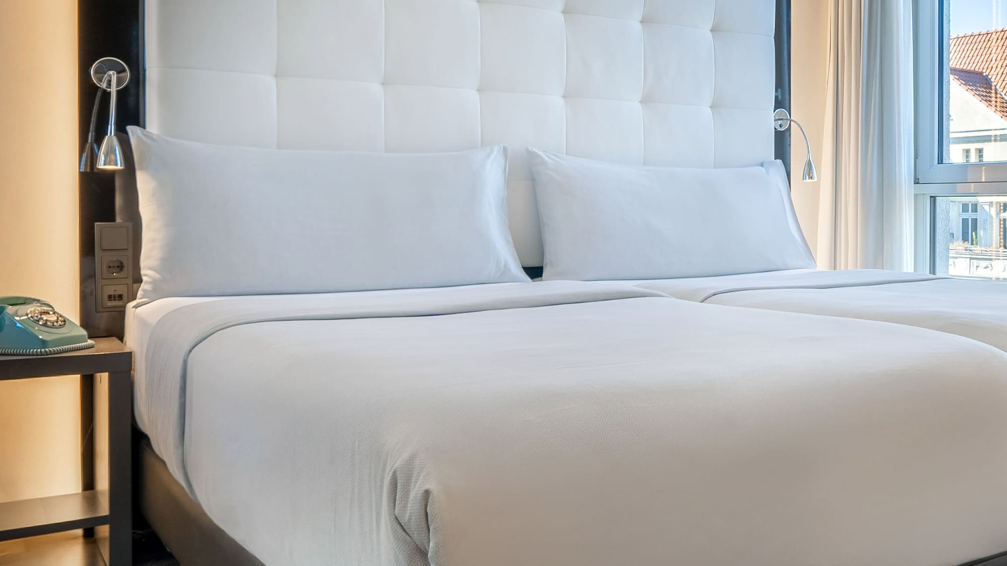 a bed with white sheets and a black headboard